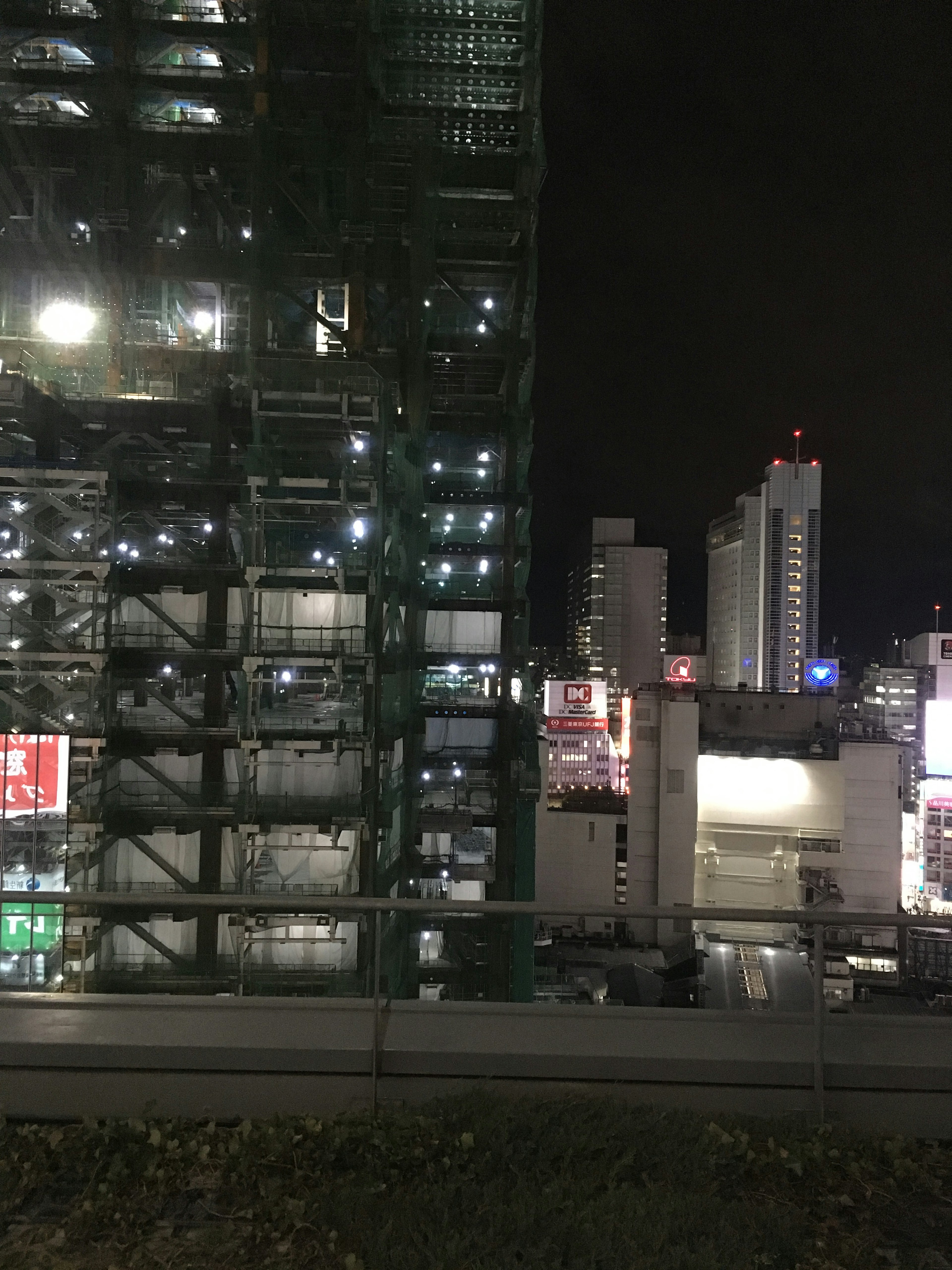 Paysage urbain nocturne avec un site de construction et des gratte-ciels environnants illuminés