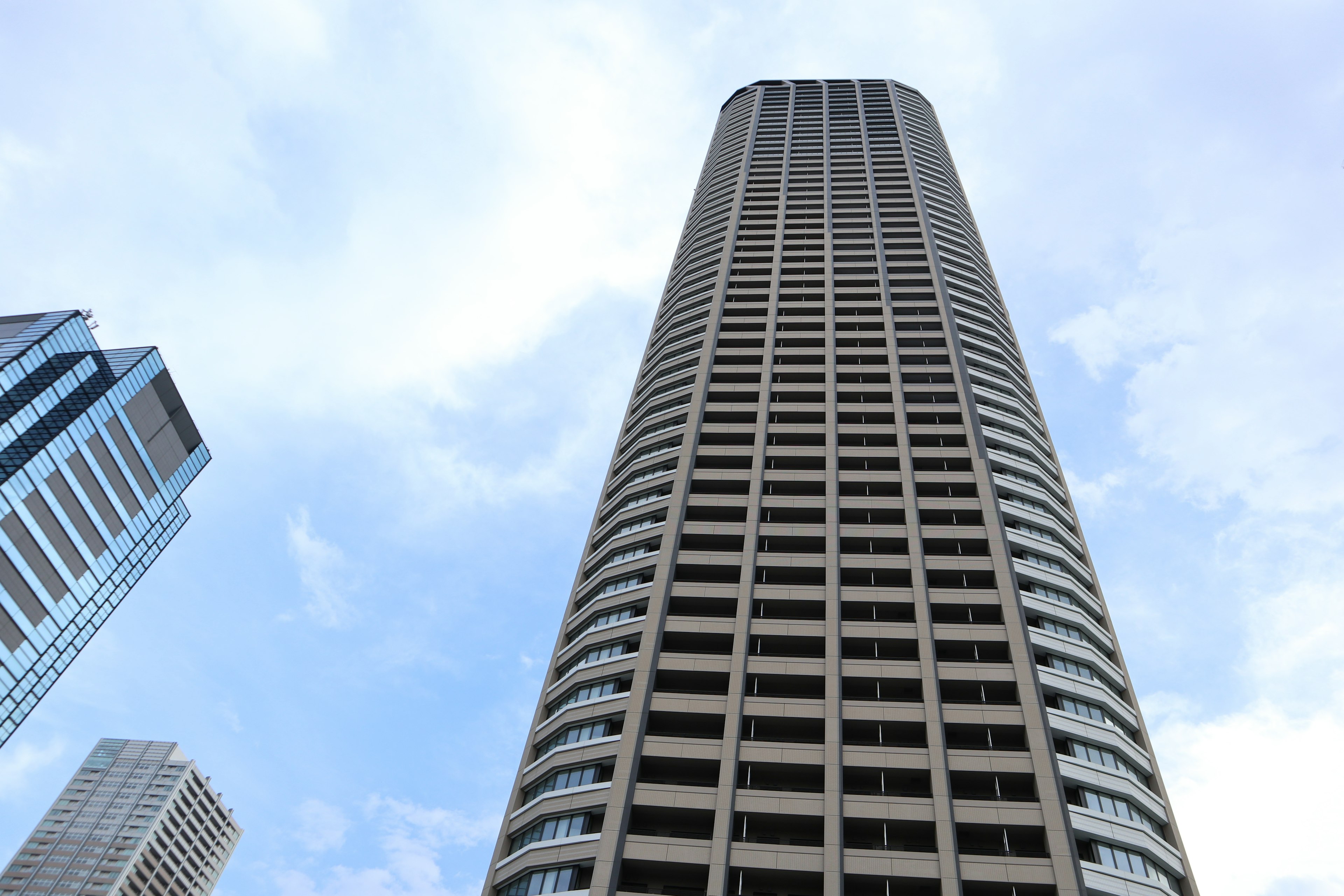 Pemandangan gedung pencakar langit dari bawah dengan langit biru