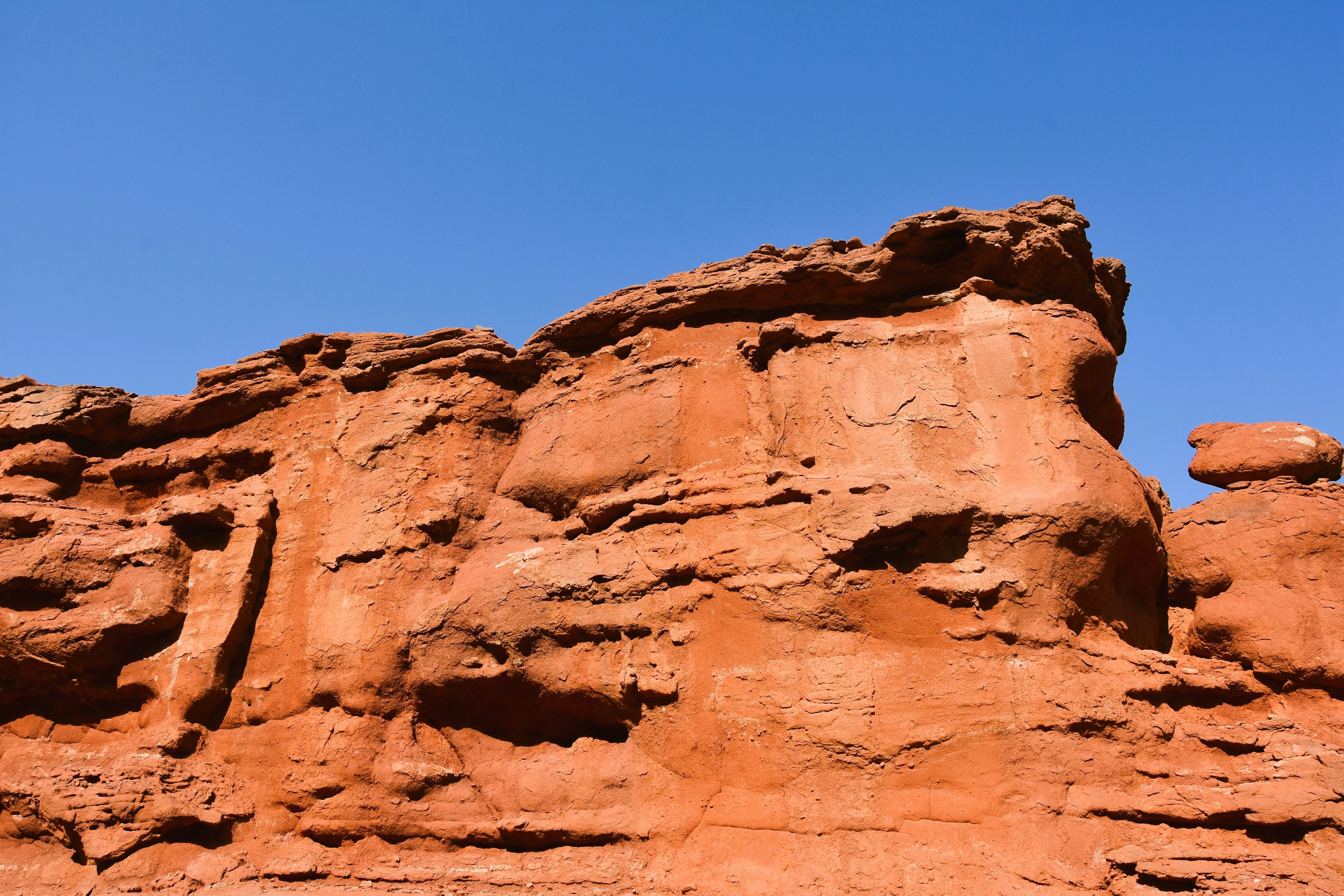 Formazioni rocciose rosse sotto un cielo blu chiaro