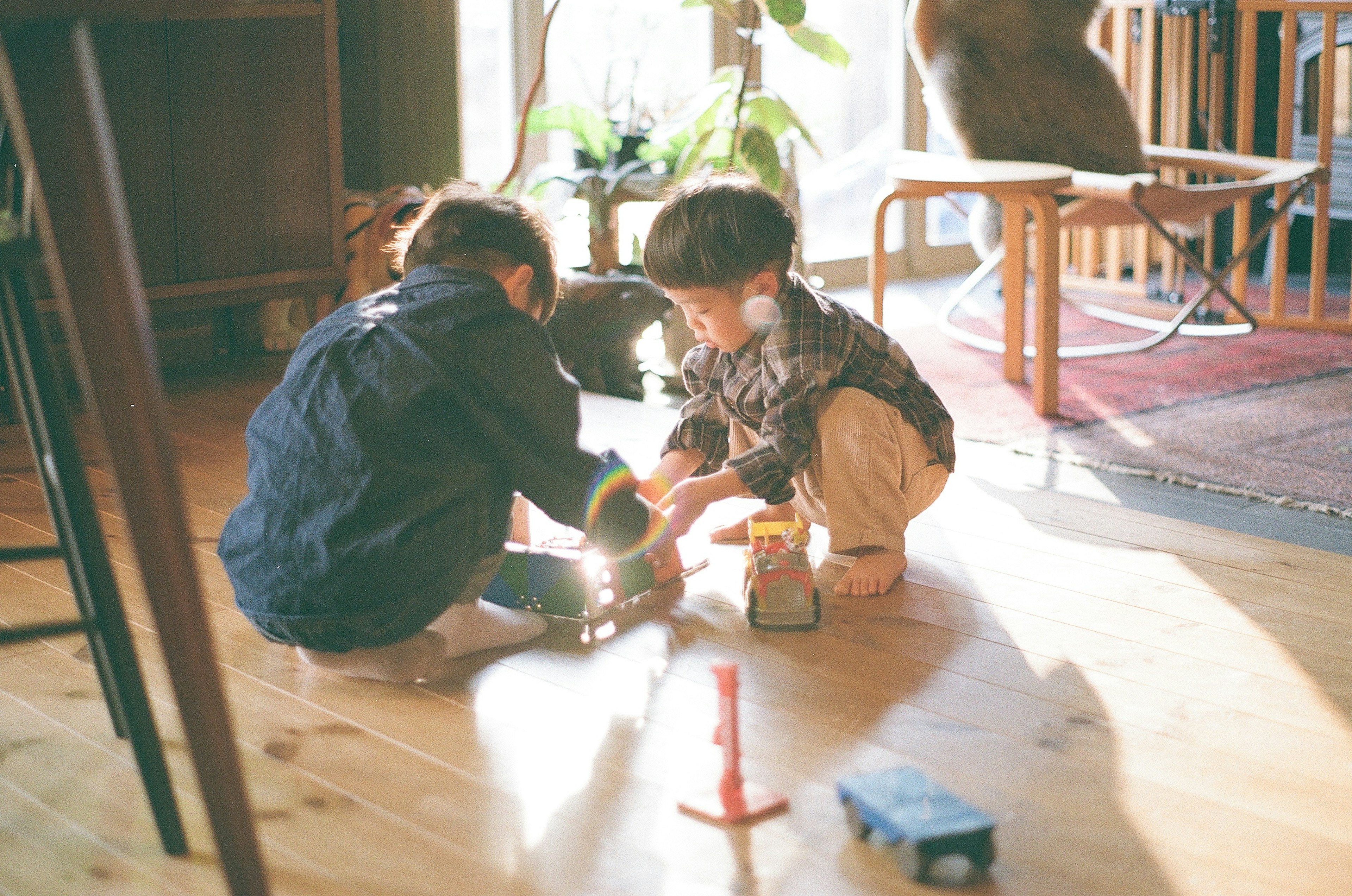 Kinder spielen mit Spielzeug auf dem Boden in einer warmen häuslichen Umgebung