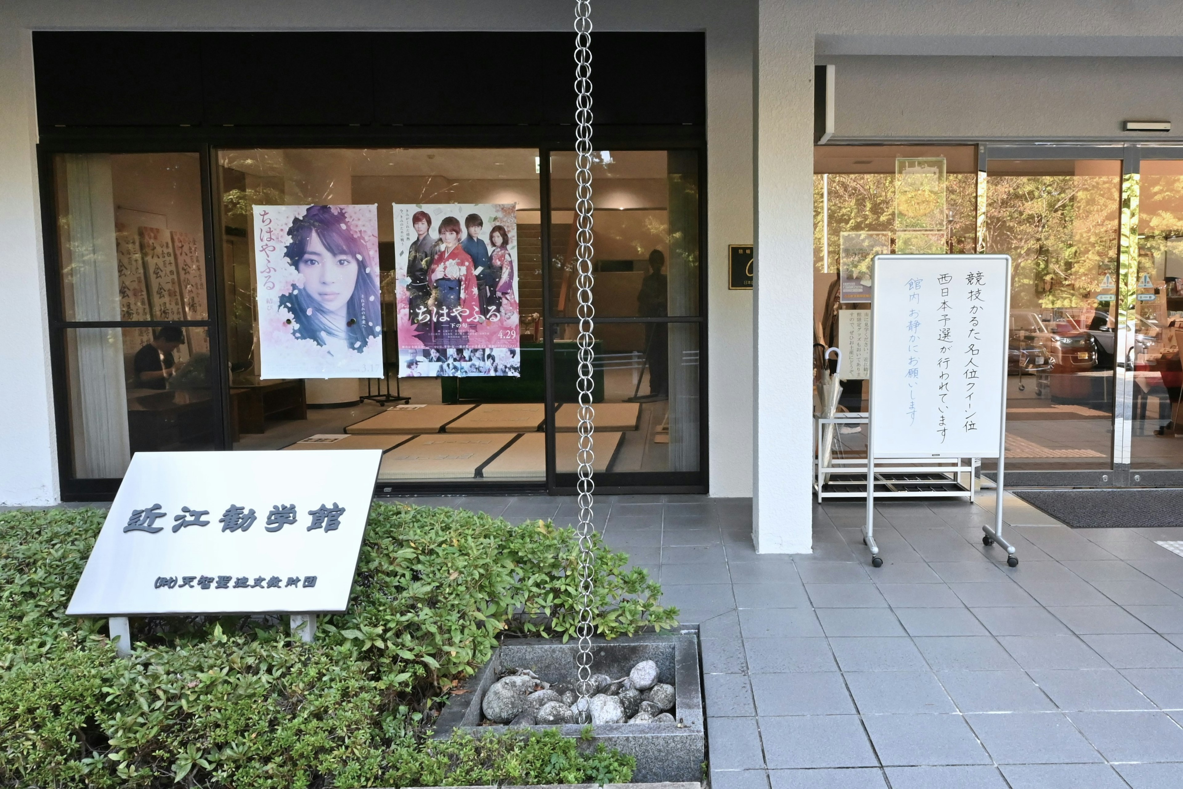 Exterior view of a cultural facility featuring posters and a sign