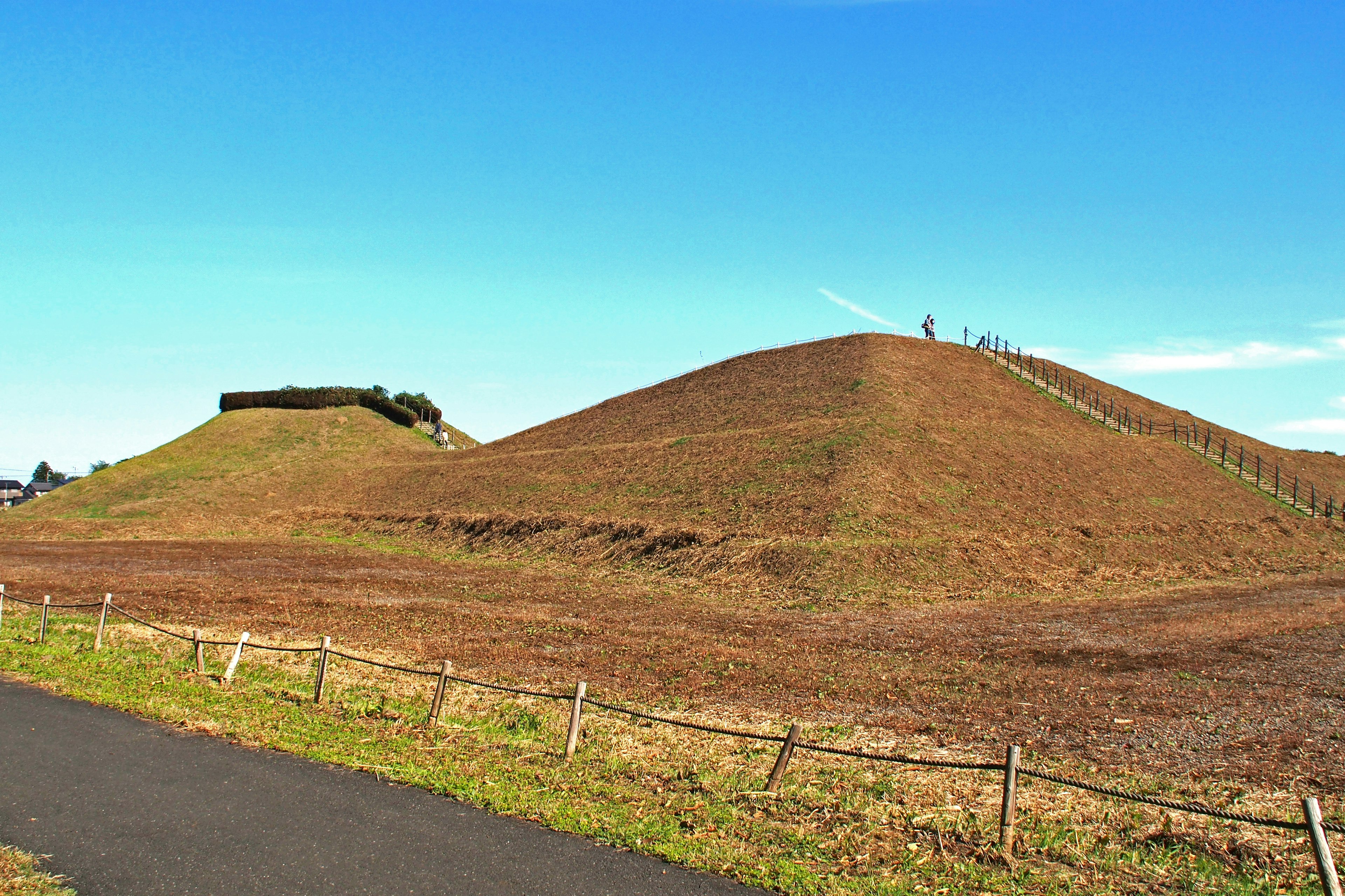 Pemandangan bukit berumput di bawah langit biru