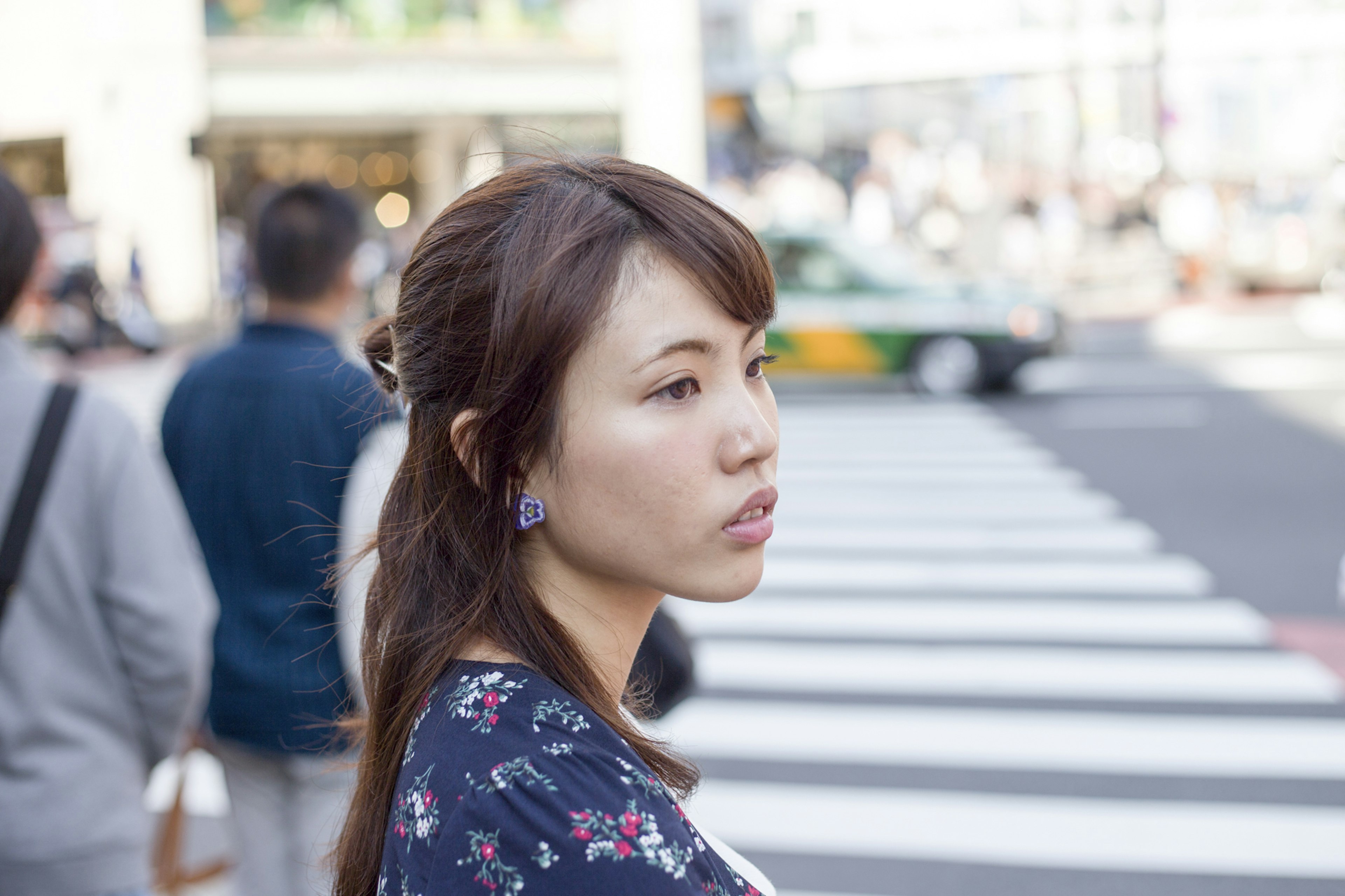 A woman lost in thought at a crosswalk