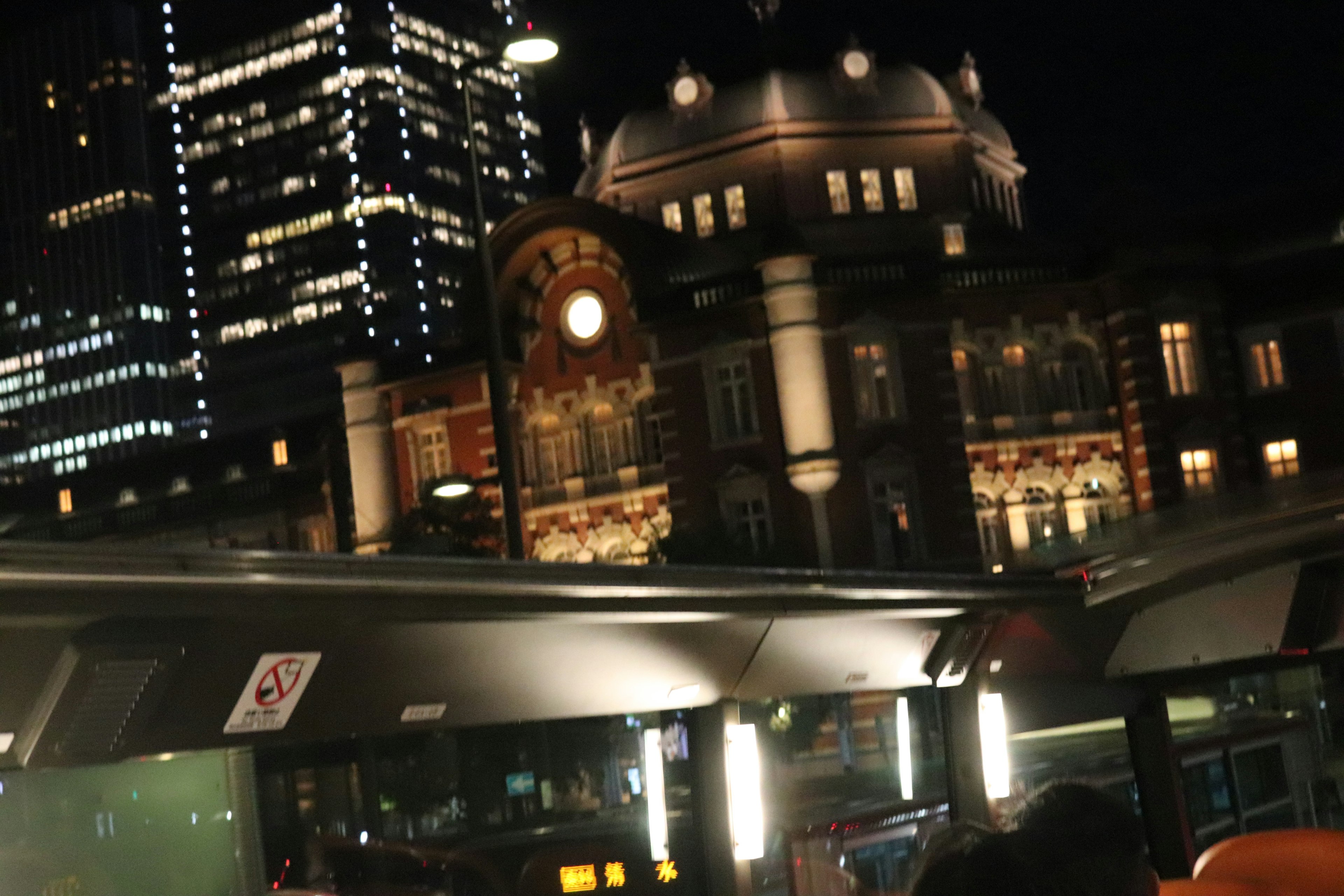 Nighttime view of Tokyo Station with modern skyscrapers in the background