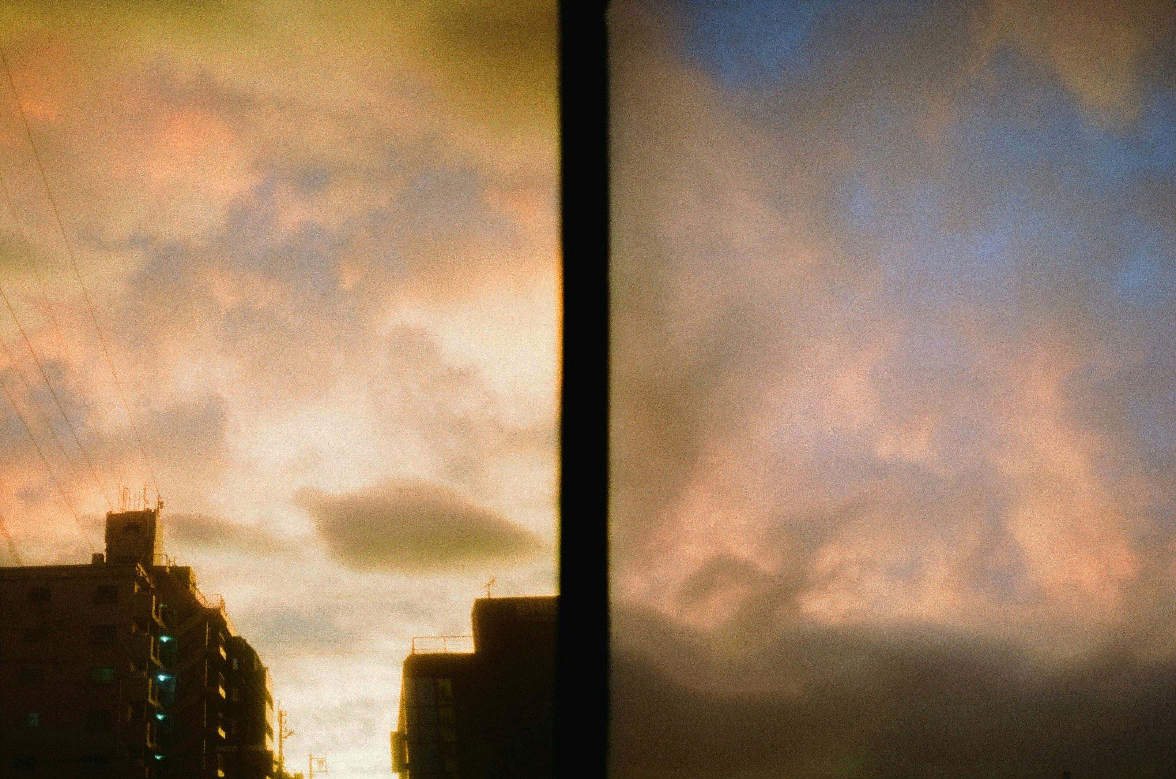 Siluet bangunan melawan langit senja dengan awan berwarna