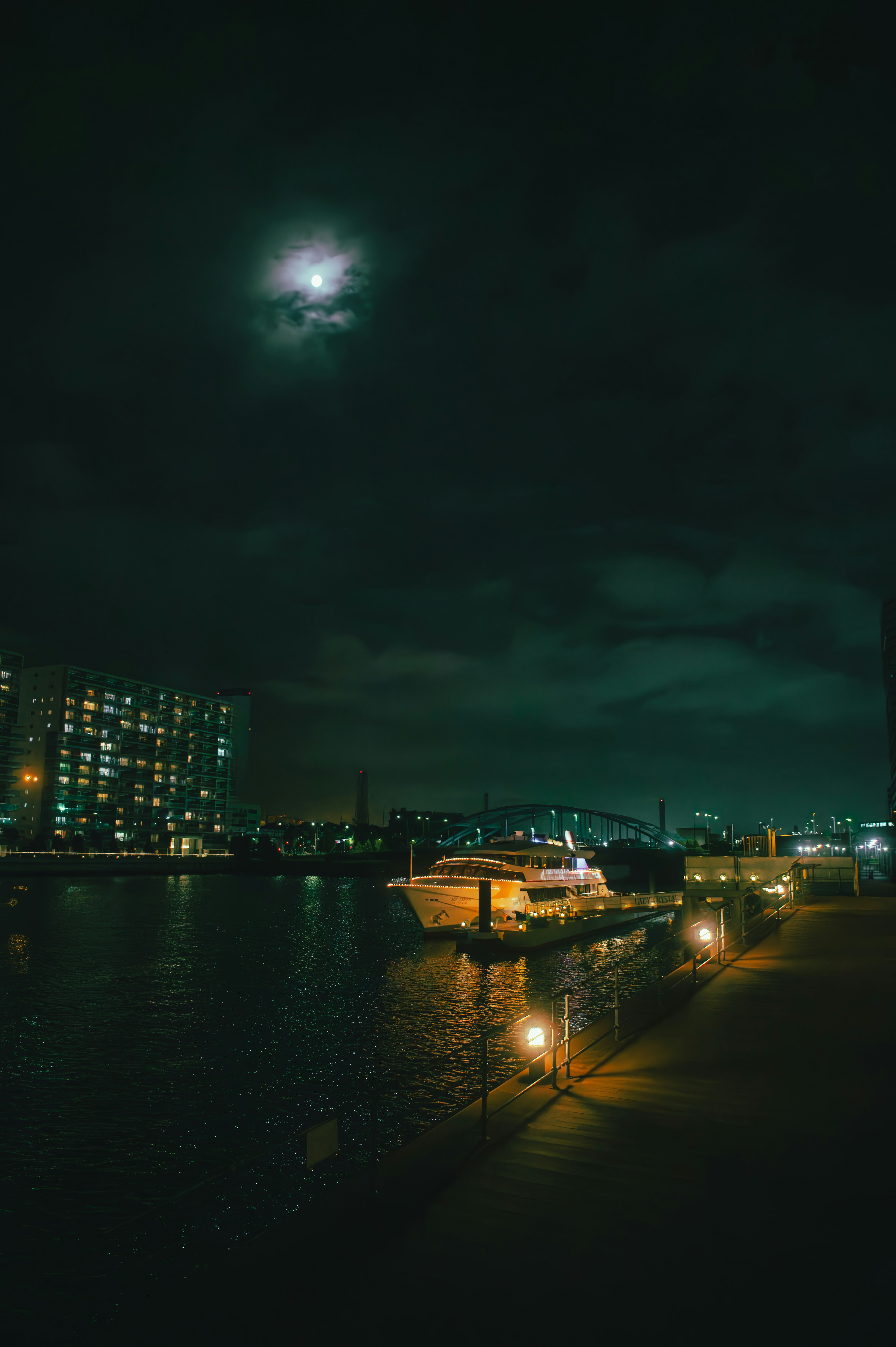 Bateau amarré la nuit avec la lumière de la lune se reflétant sur l'eau