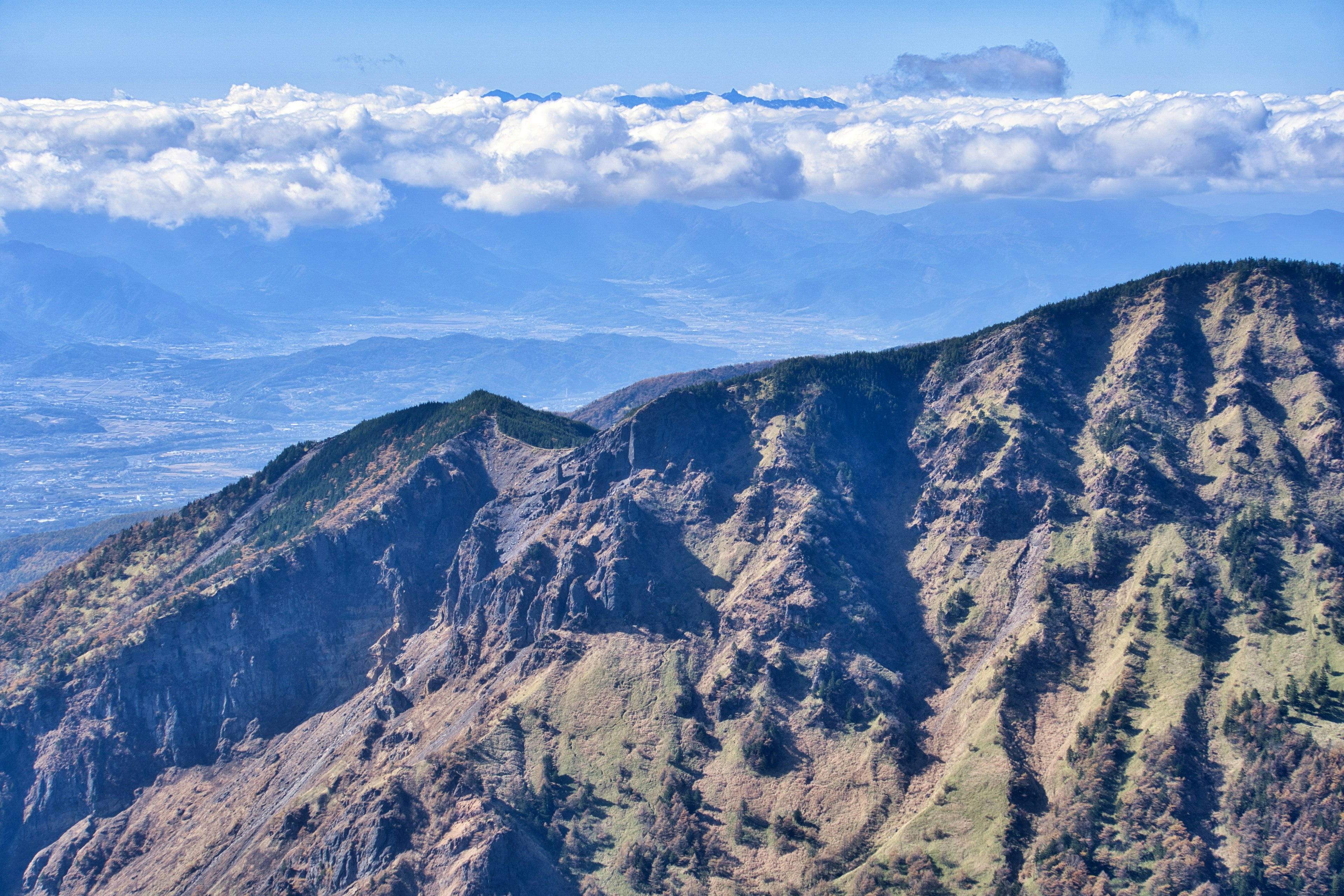 Vista panoramica di montagne aspre sotto un cielo blu e nuvole