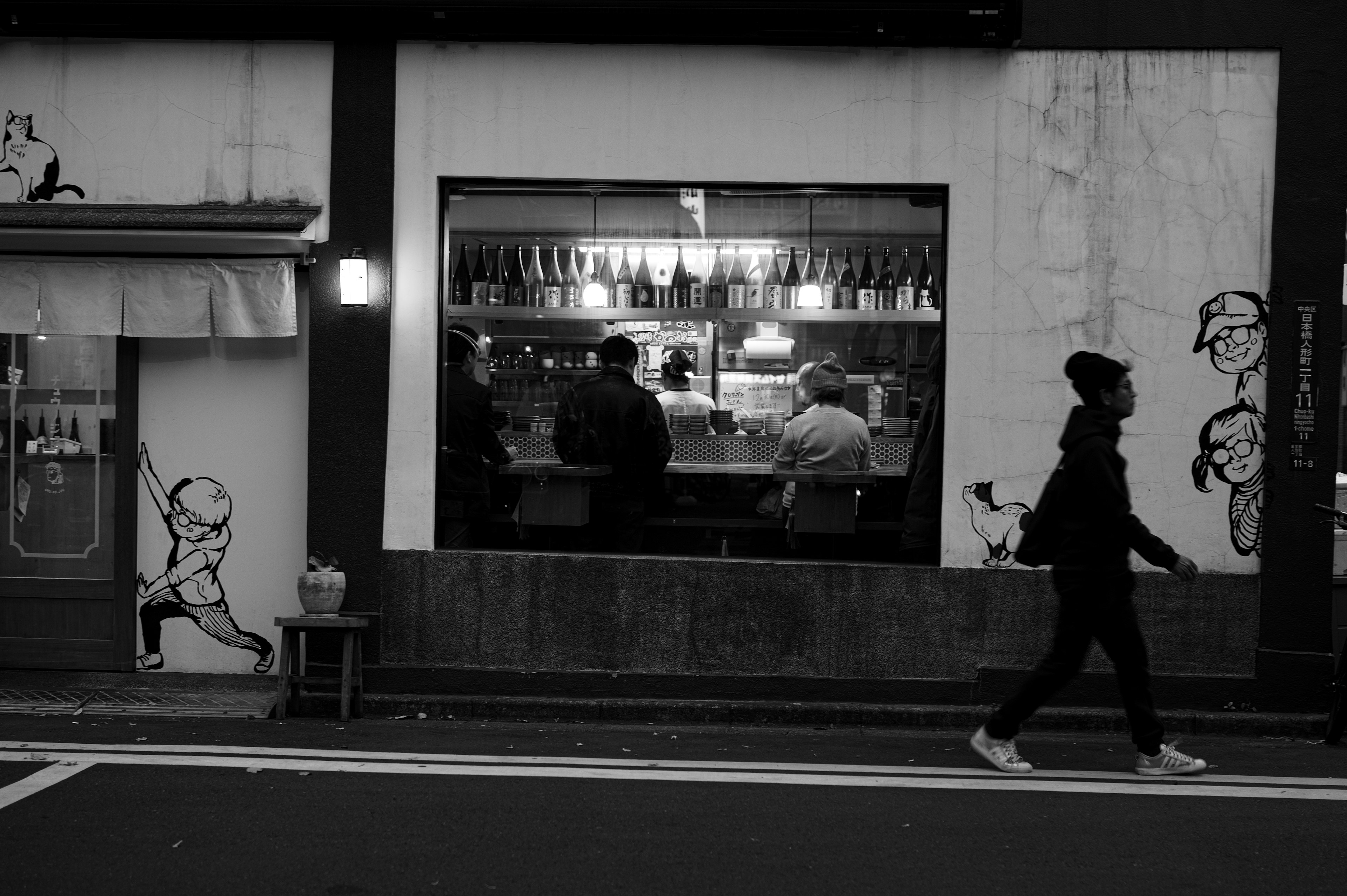 Vista di un caffè in bianco e nero con persone che cenano al bancone