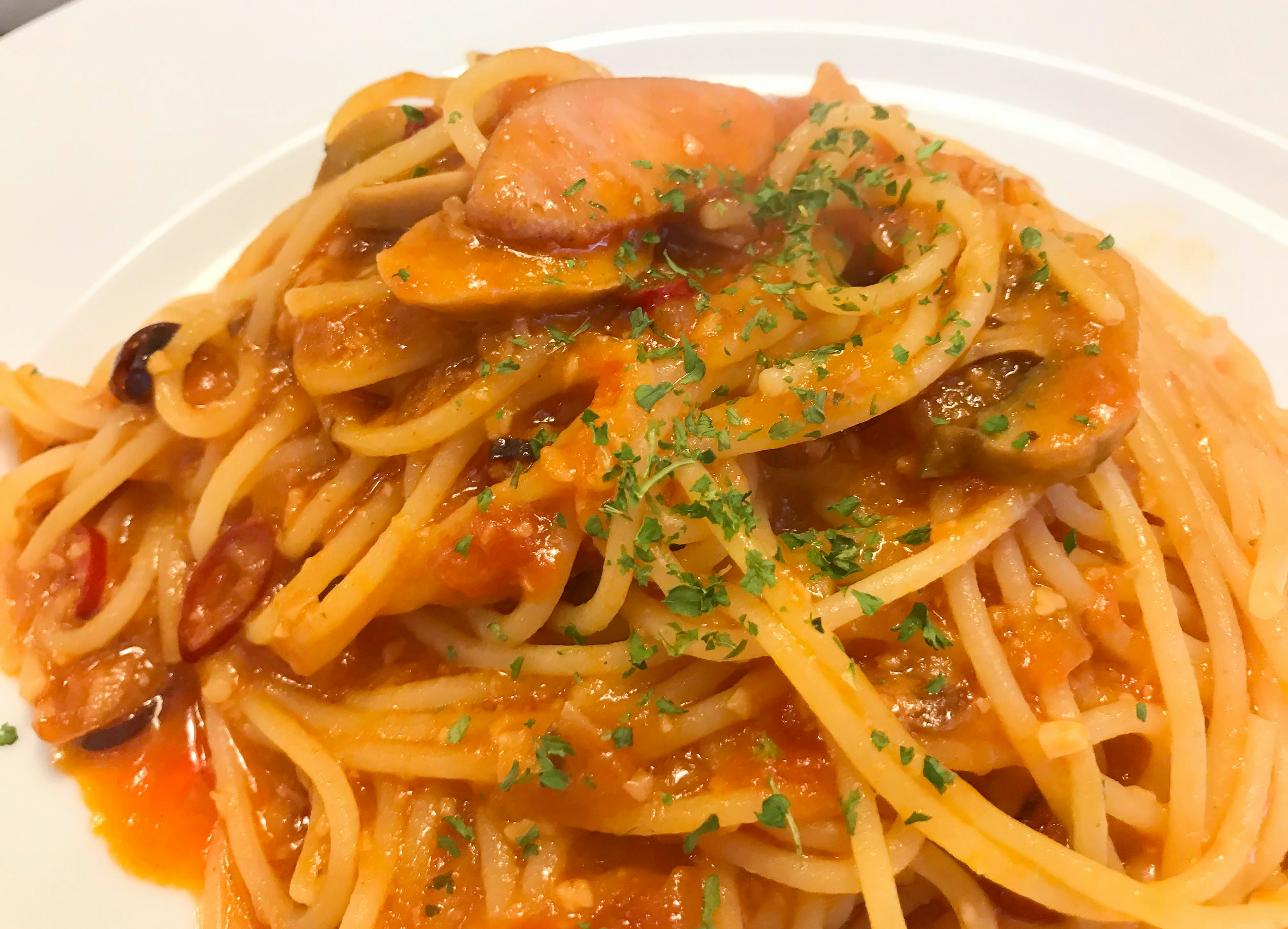 Pasta con salsa di pomodoro e guarnizione di prezzemolo