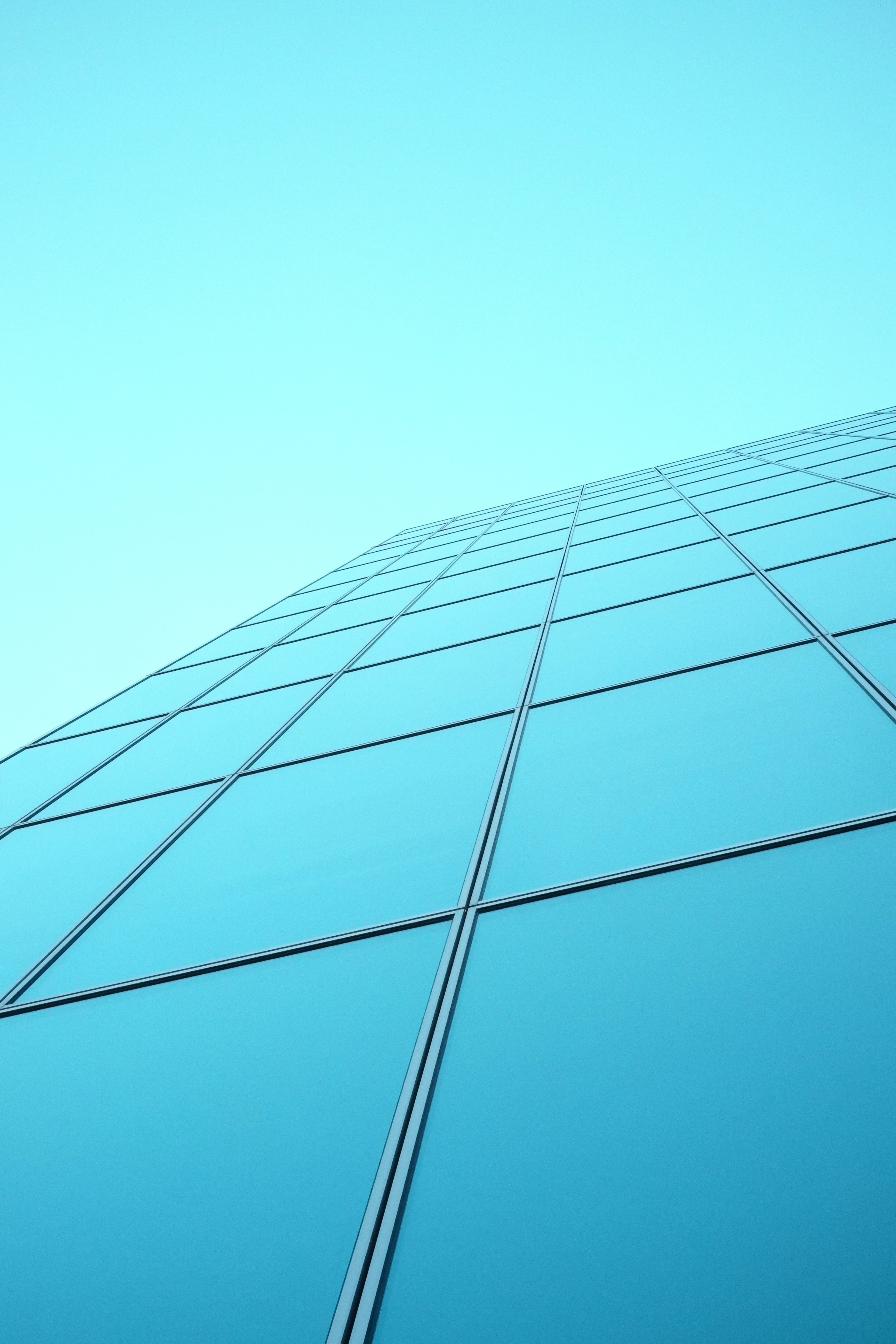 Facciata di un moderno edificio in vetro contro un cielo blu