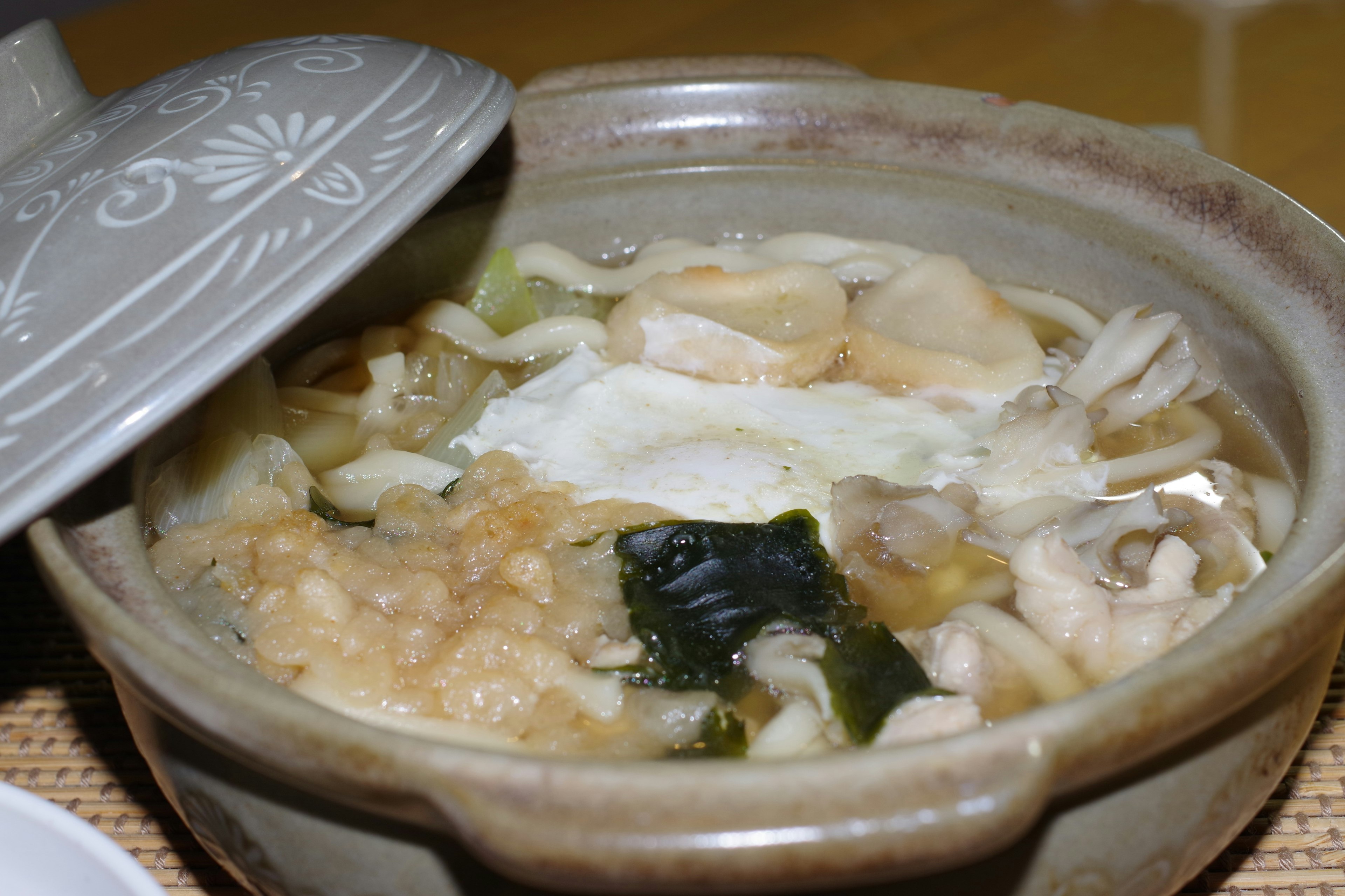 Image of a hot pot dish with various ingredients visible under the opened lid