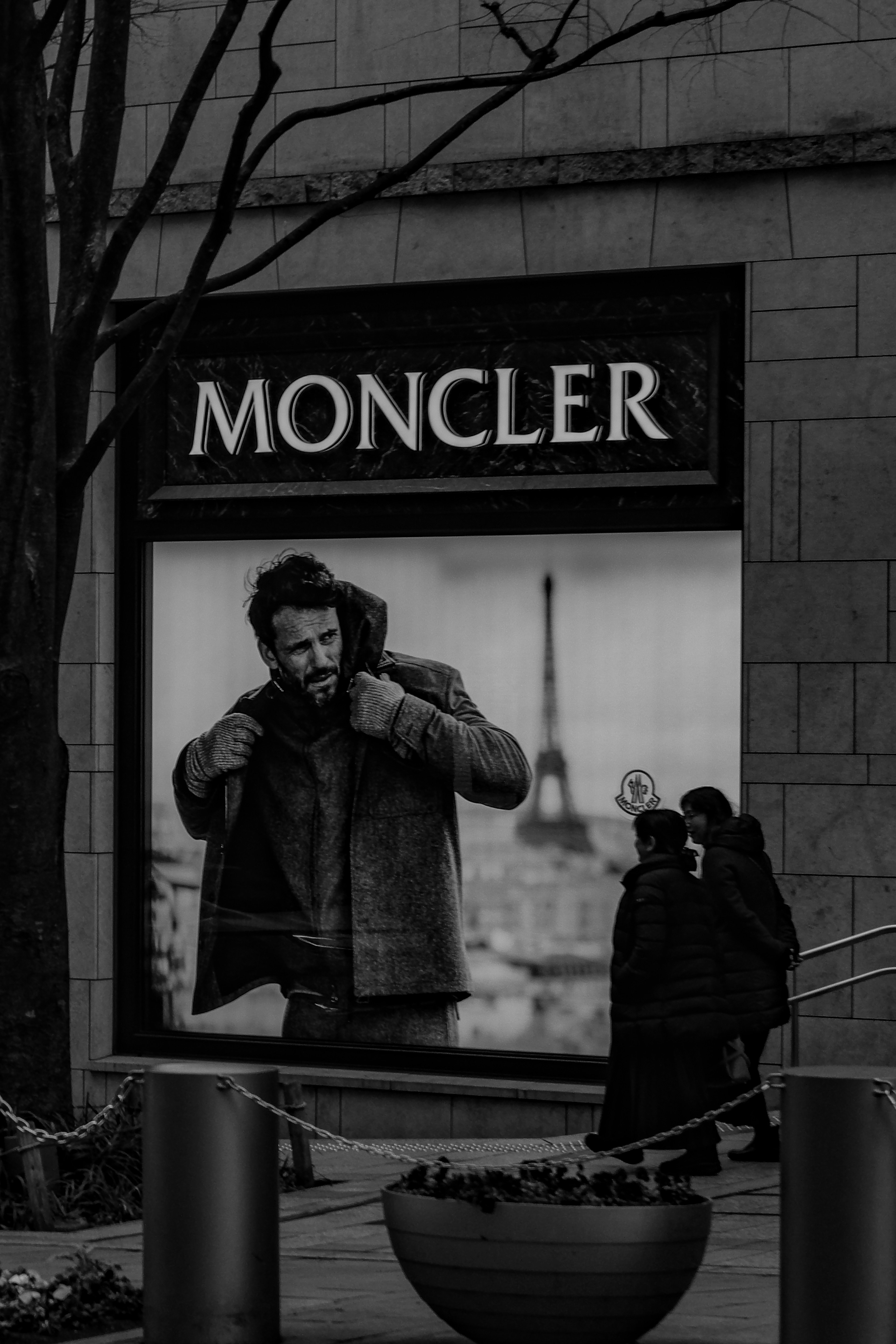 Uomo in pubblicità Moncler con sfondo della Torre Eiffel