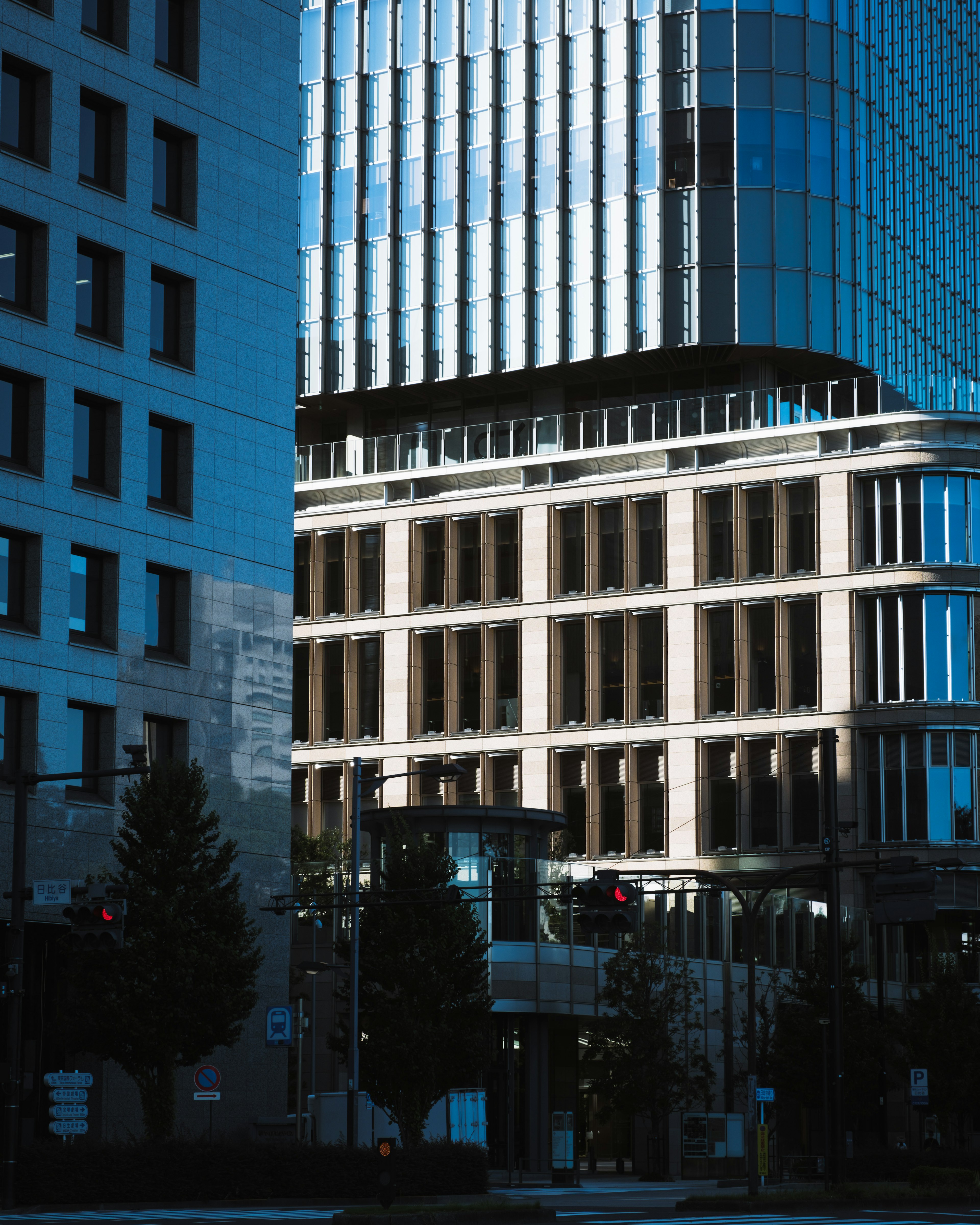 Urban landscape featuring reflections of a blue glass skyscraper and modern buildings