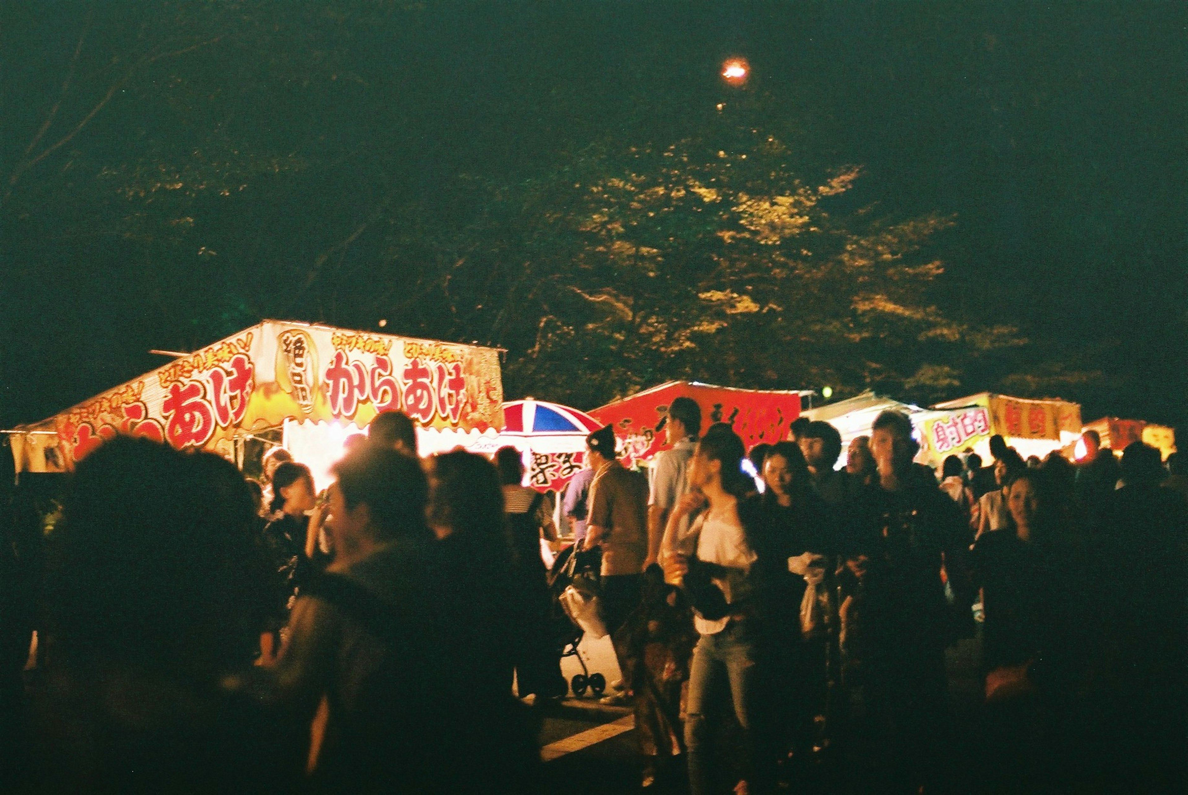 Escena nocturna vibrante con puestos de festival y multitudes