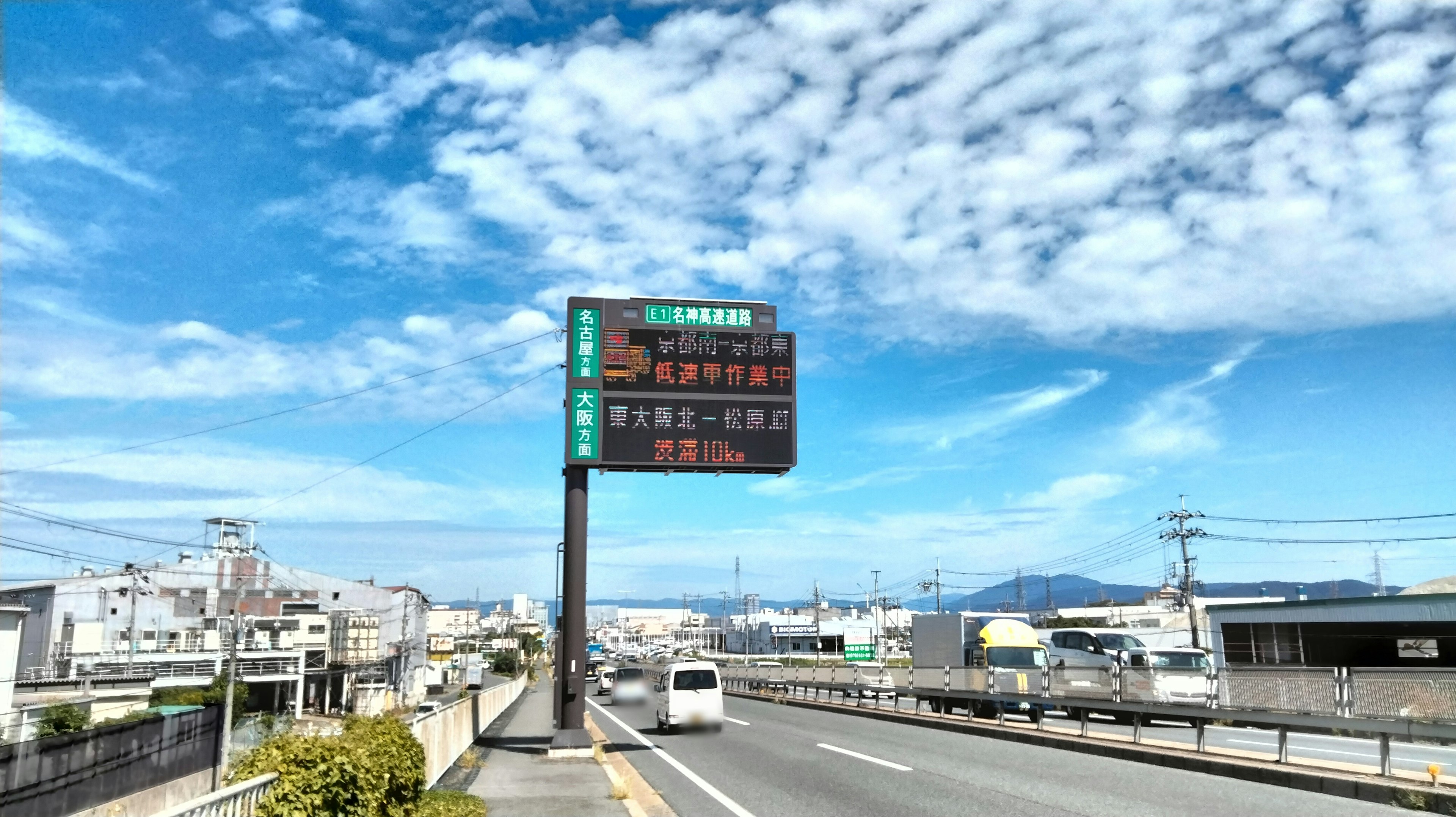 Road scene with digital sign under blue sky