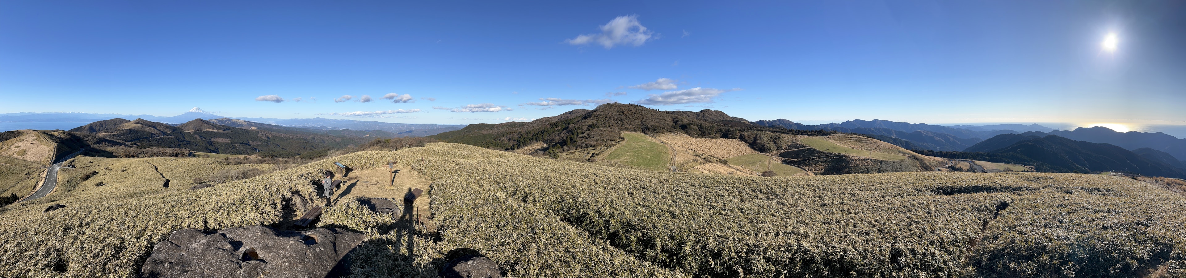 Vista panorámica de vastas praderas y montañas cielo azul claro con sol brillante