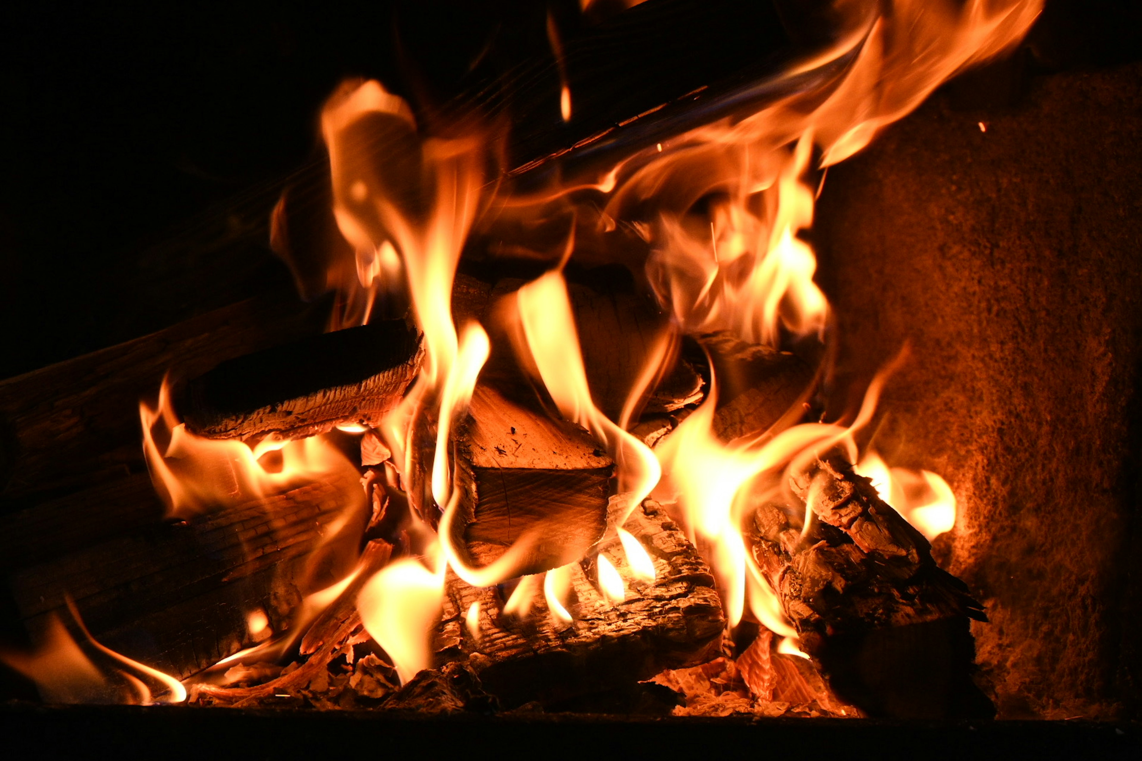 Primo piano di un fuoco caldo con fiamme e braci ardenti