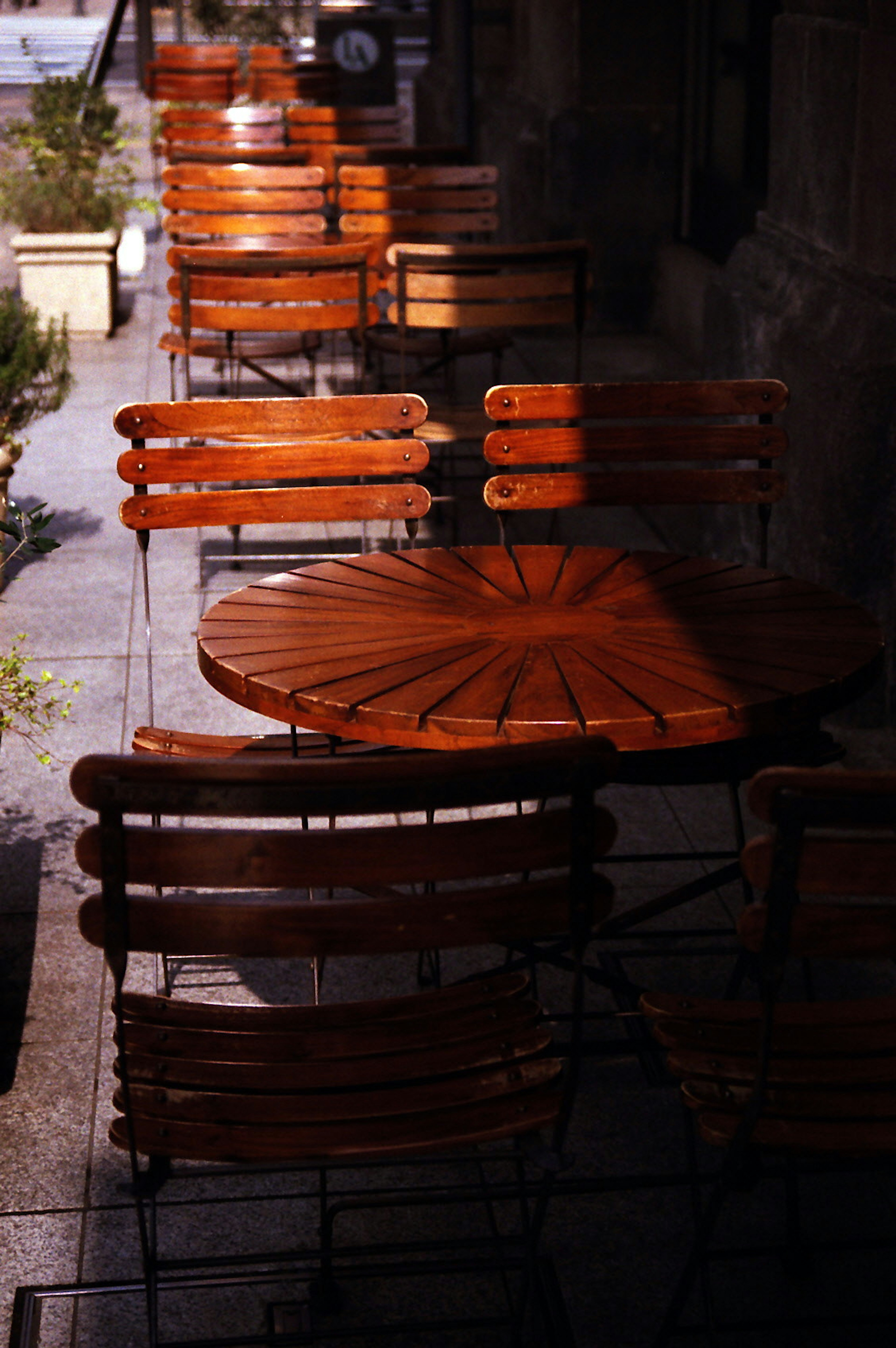 Holztische und -stühle vor einem Café angeordnet