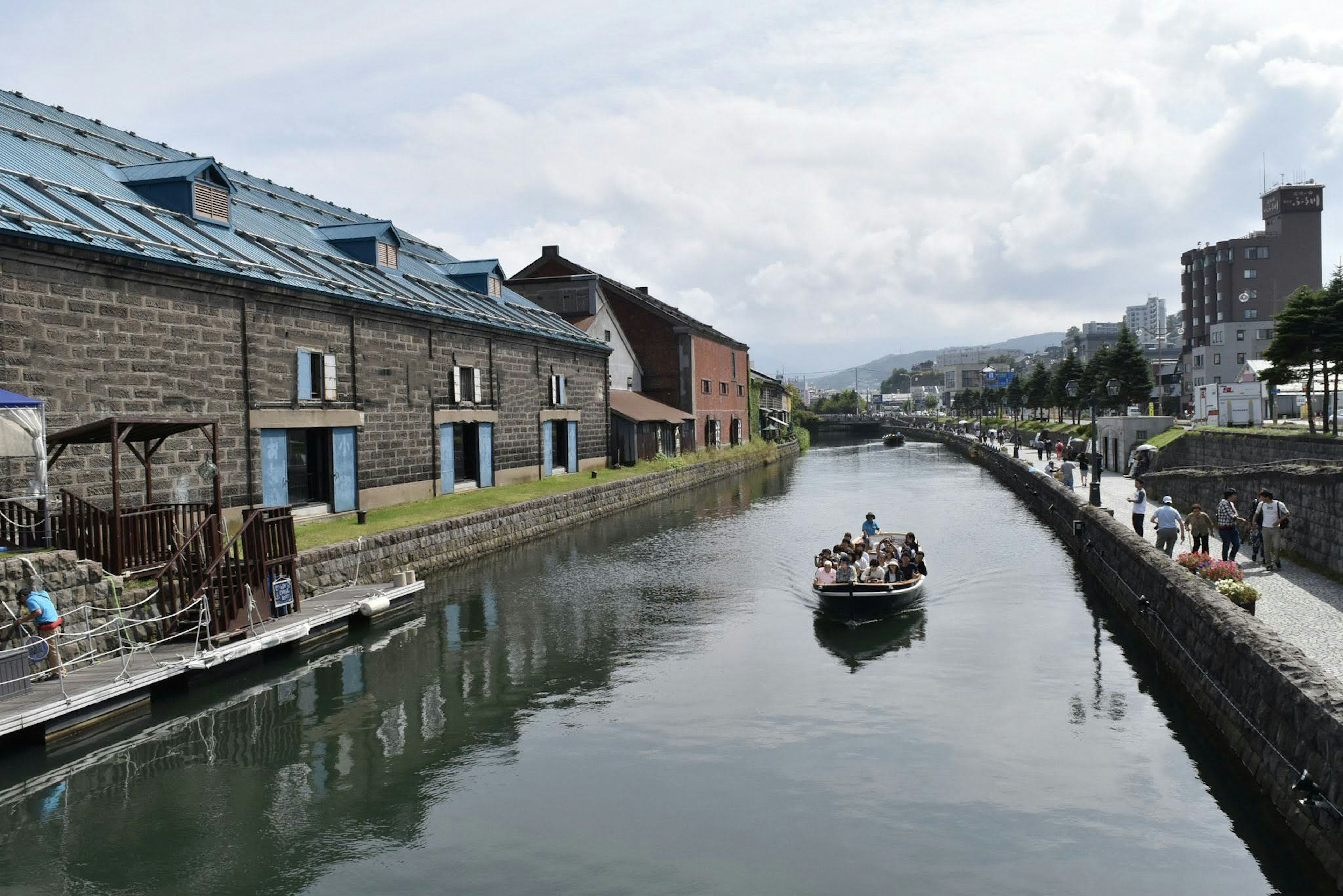 小樽の運河に沿った歴史的な石造りの建物とボートが浮かぶ風景