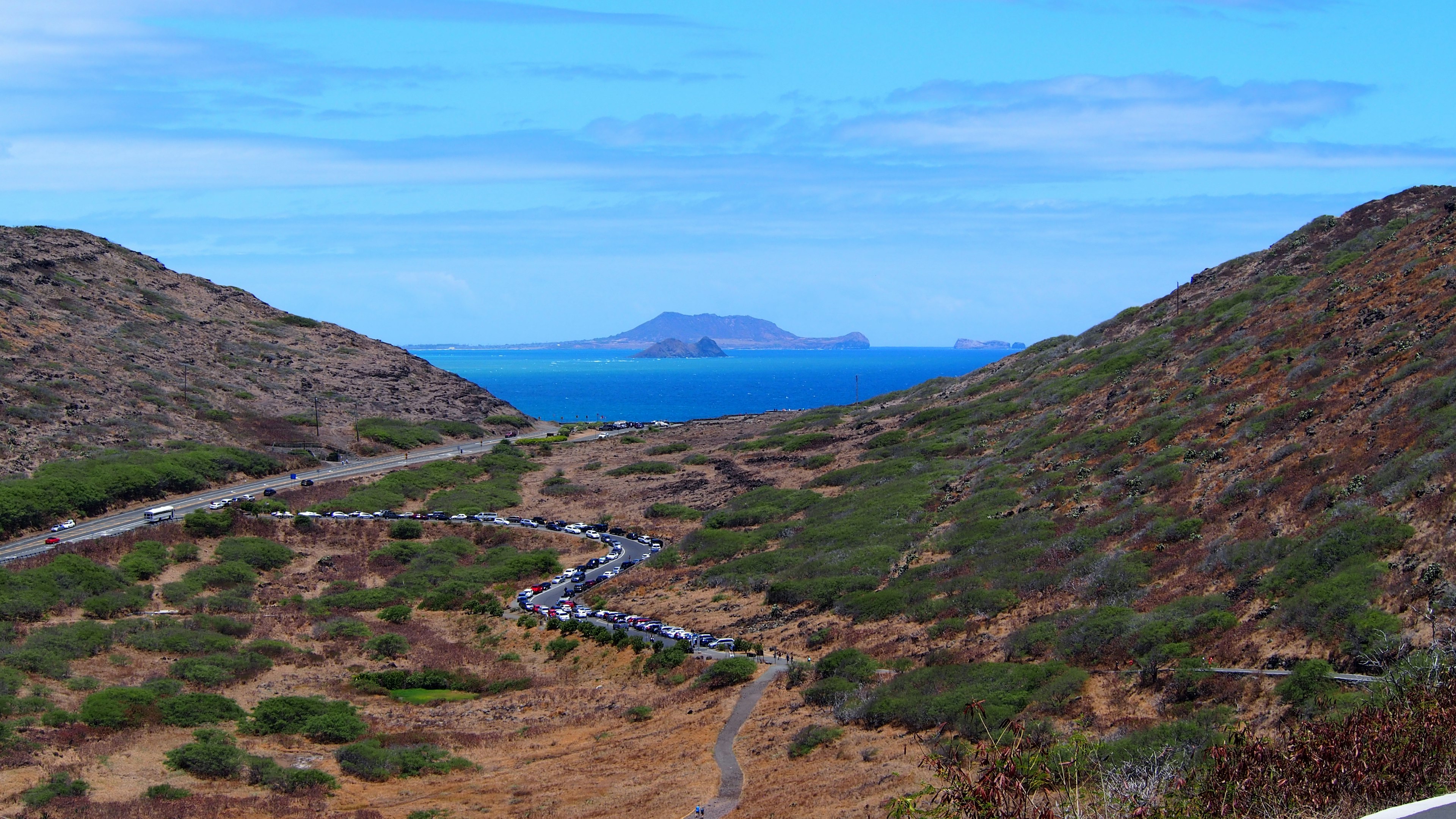 Vue panoramique des montagnes et de la verdure avec une île lointaine et l'océan