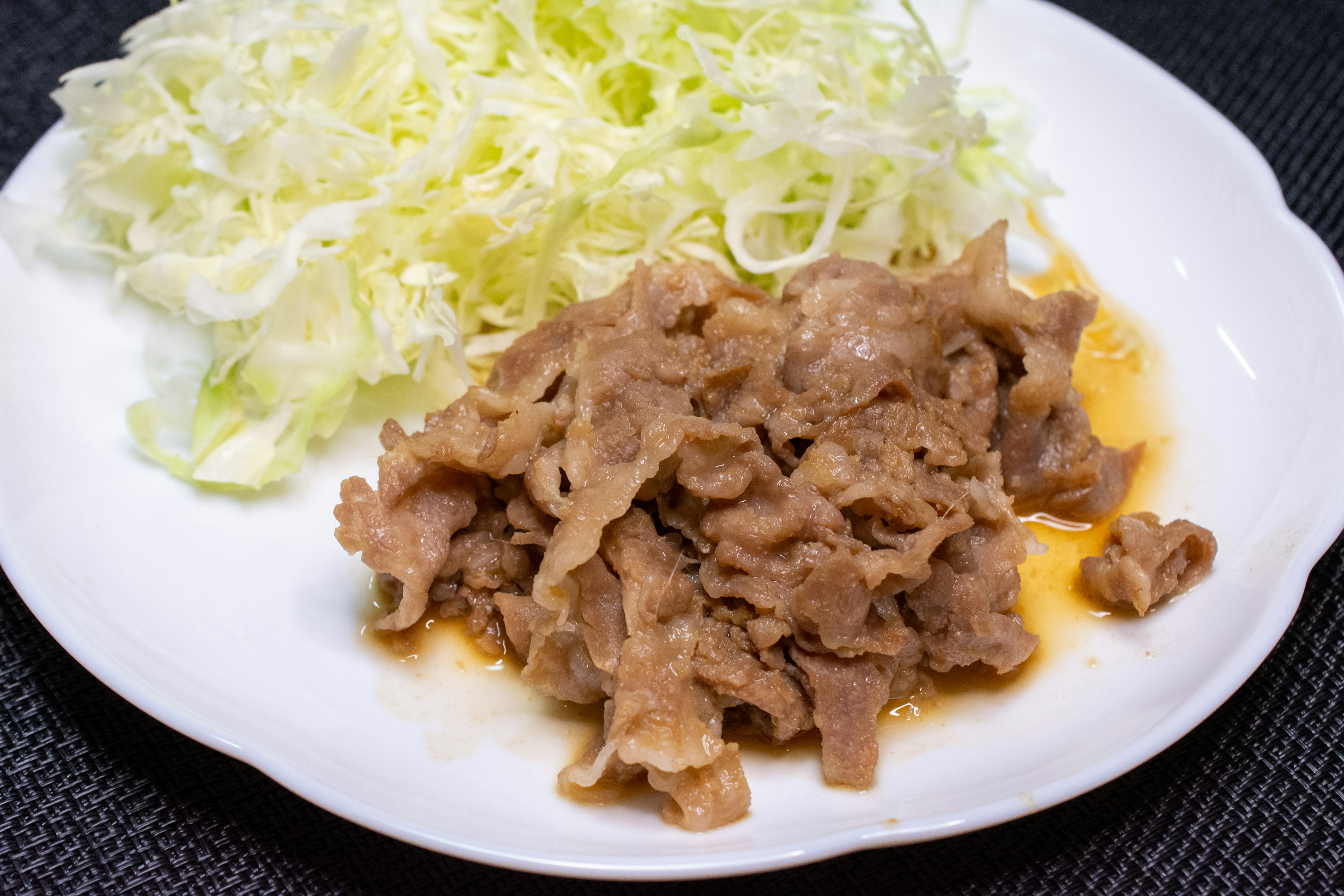 白い皿に盛られたキャベツと肉の料理