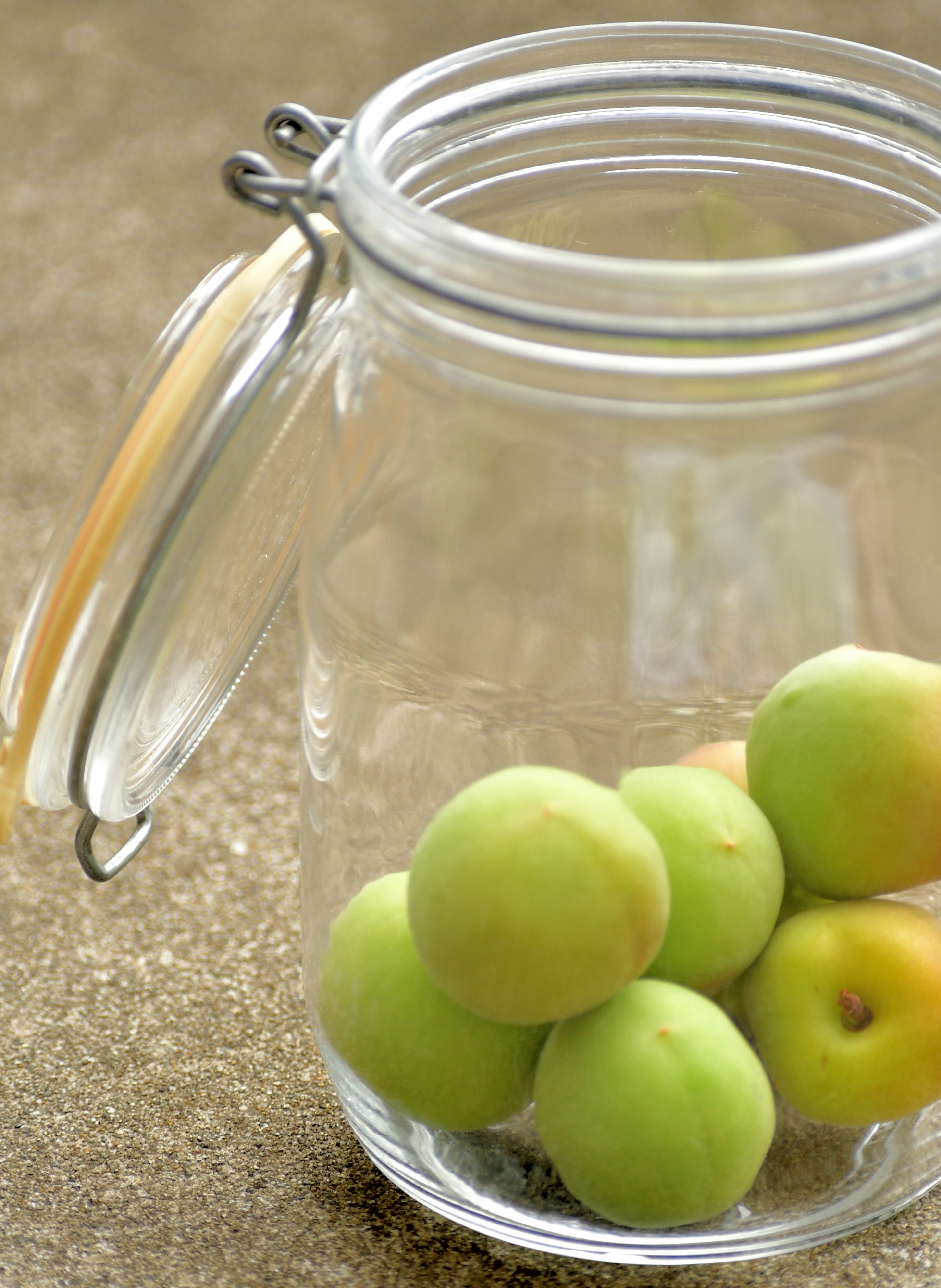 Un tarro de vidrio transparente que contiene frutas verdes