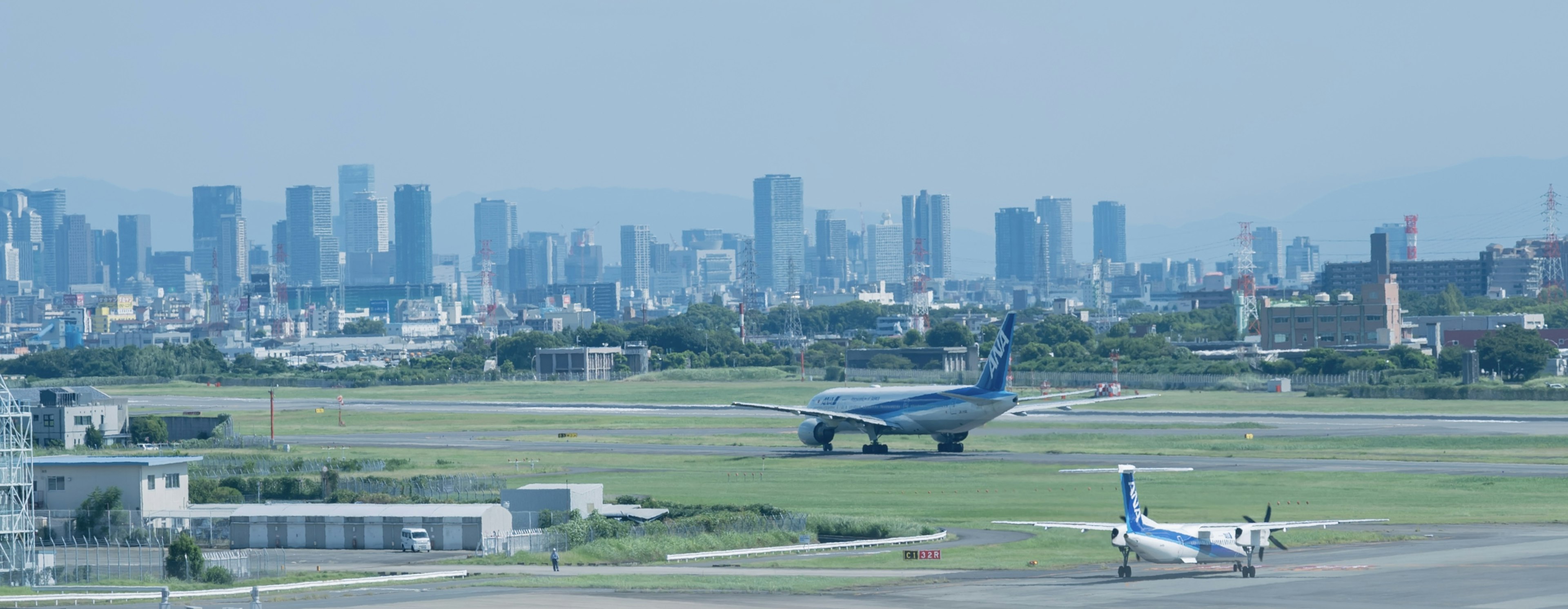 Airplanes on the runway with a city skyline in the background