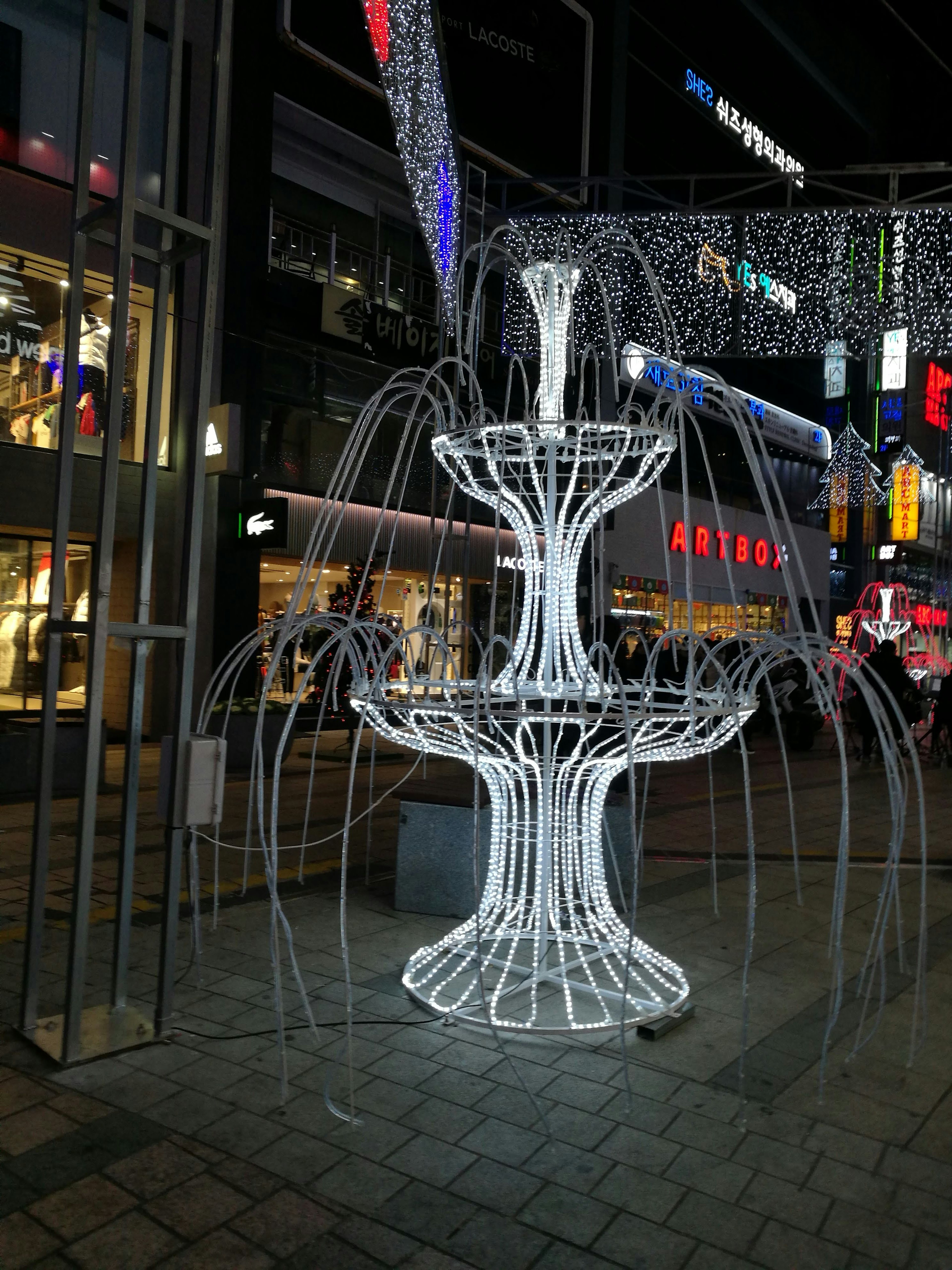 Fontana decorativa illuminata in un contesto urbano