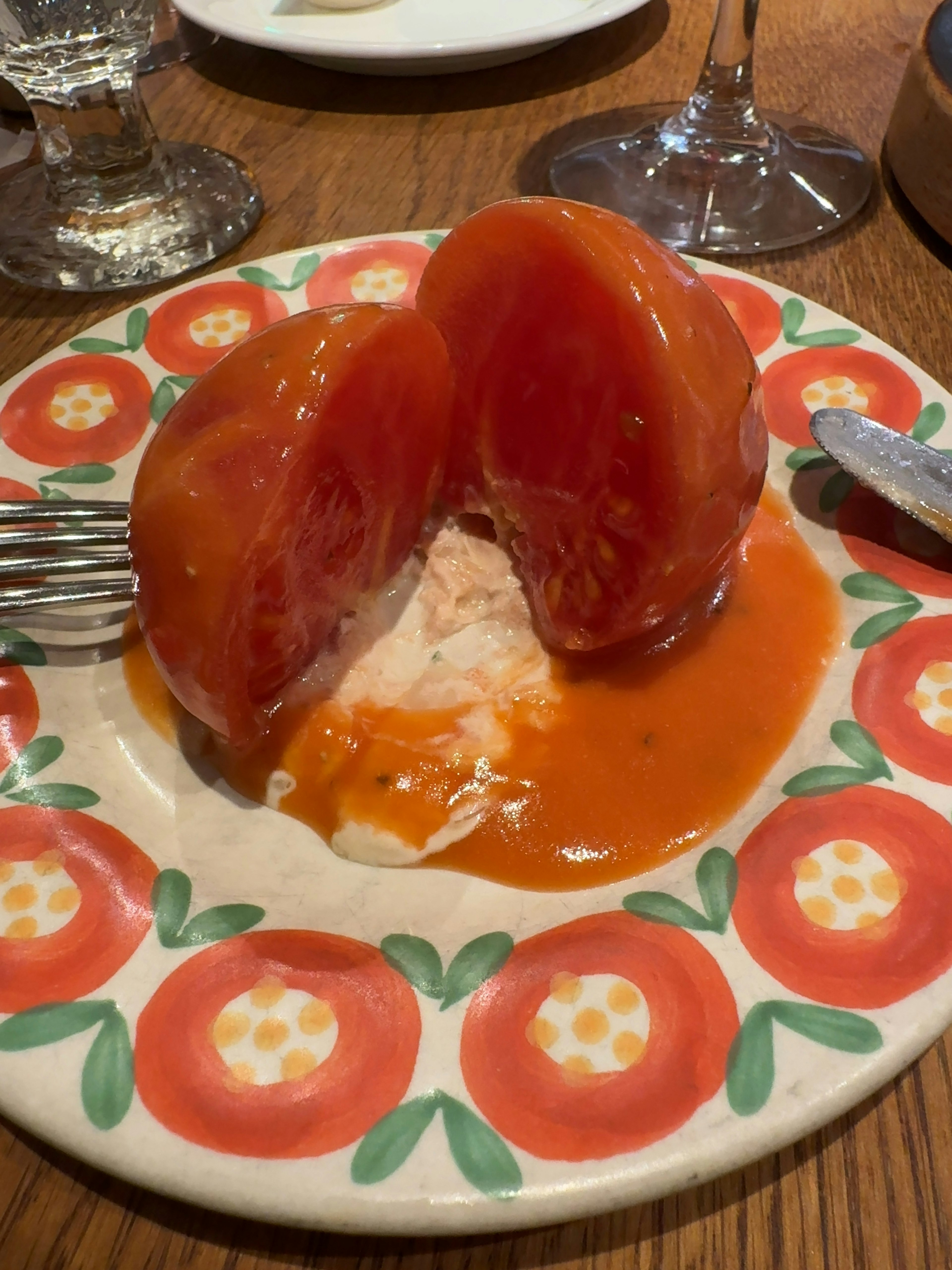 A plate featuring a halved red tomato jelly with a creamy filling