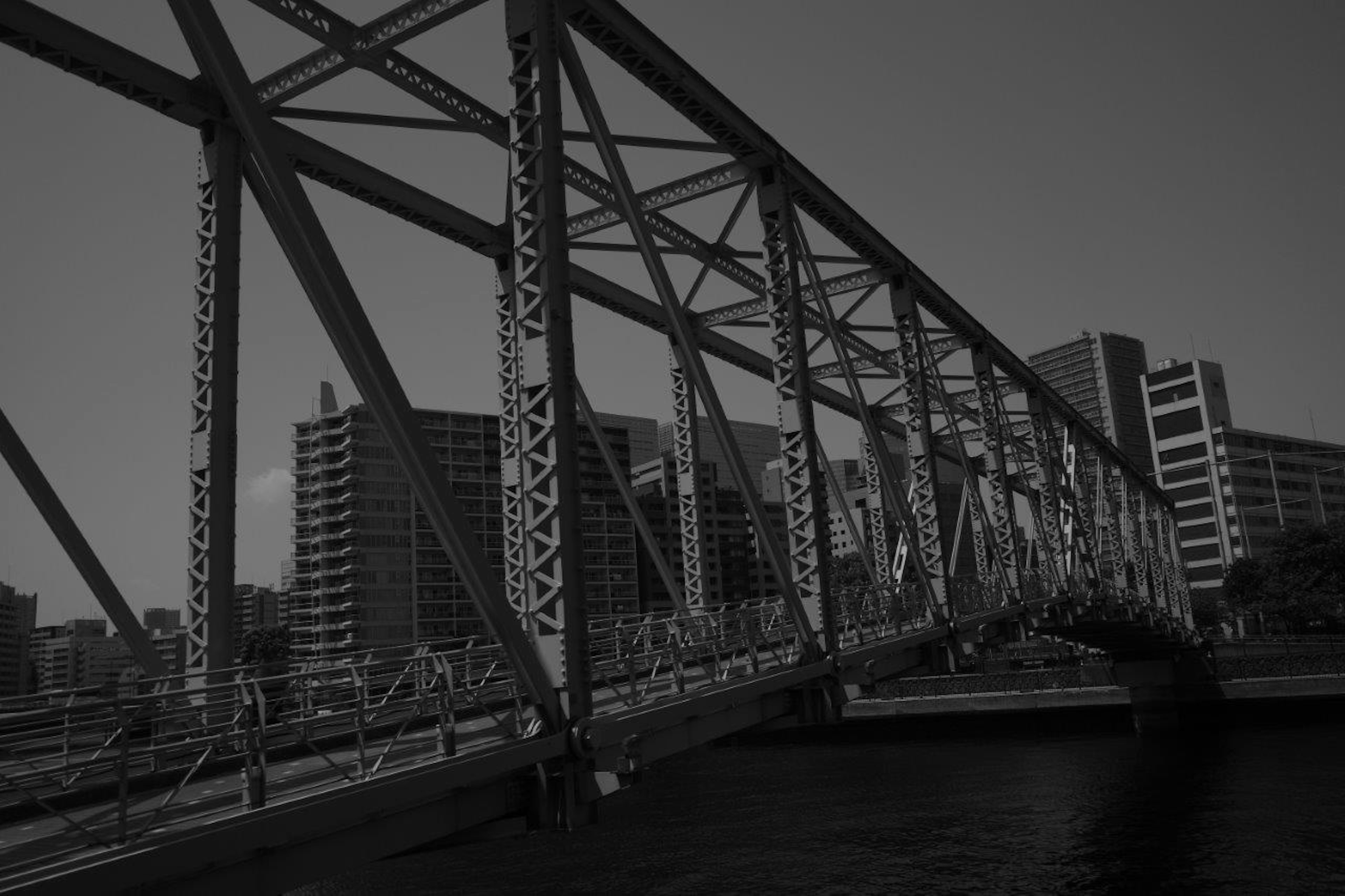 Schwarz-weiß Foto einer Brücke mit urbanem Hintergrund und strukturellem Design