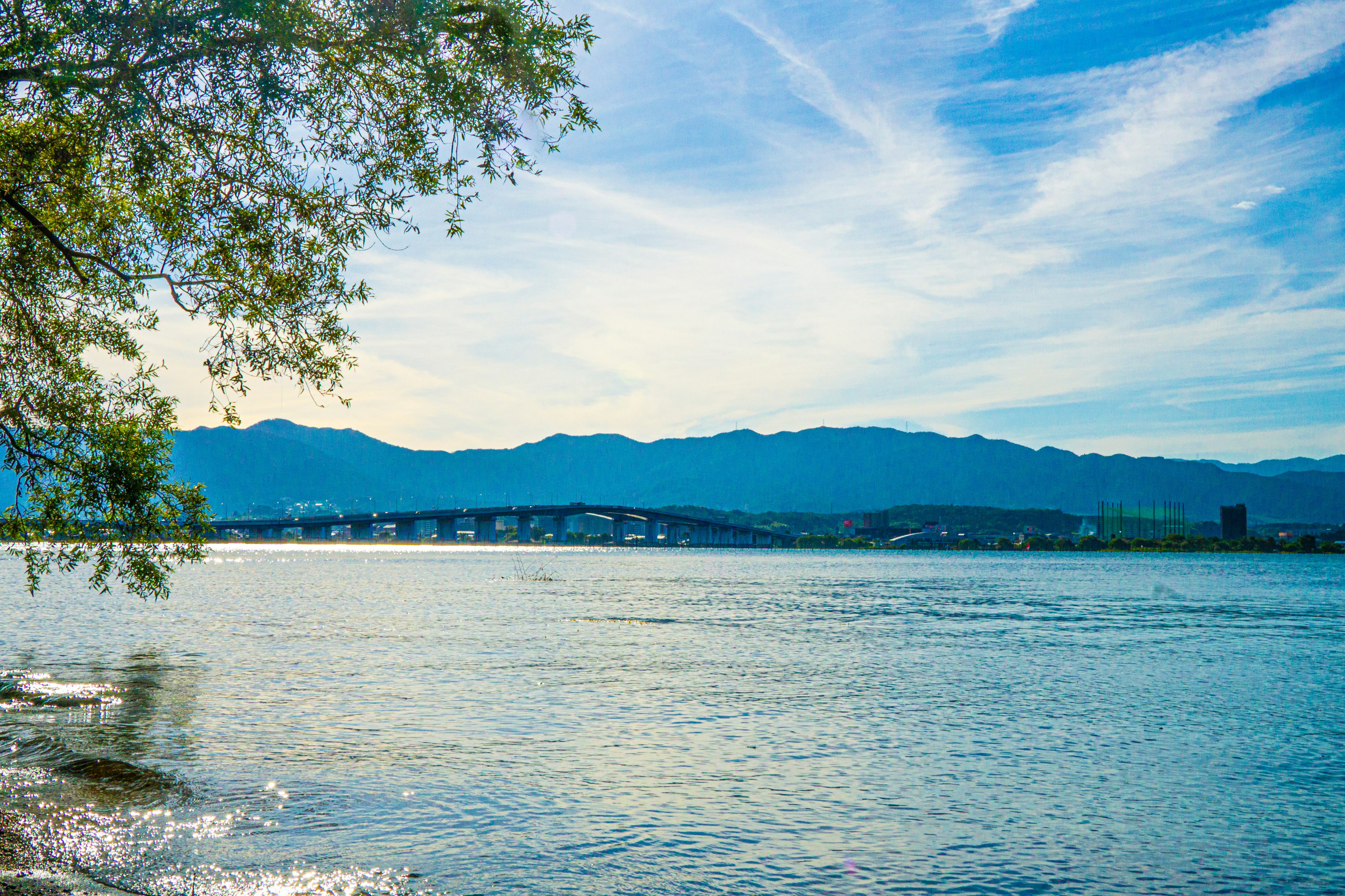 Malersicher Blick auf einen See mit blauem Himmel und Bergen im Hintergrund