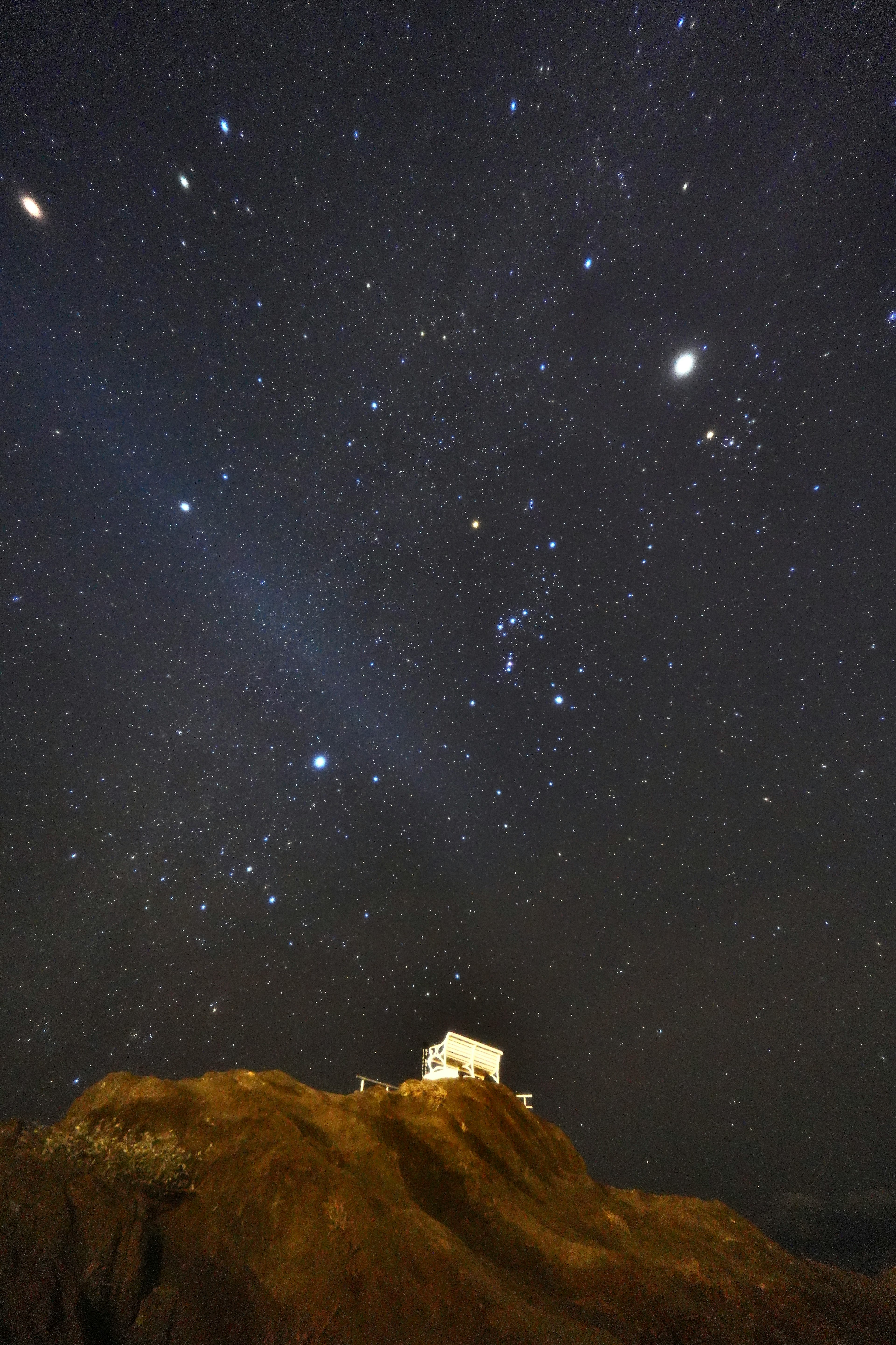 Ein kleines Haus unter einem sternklaren Himmel mit sichtbaren Sternbildern