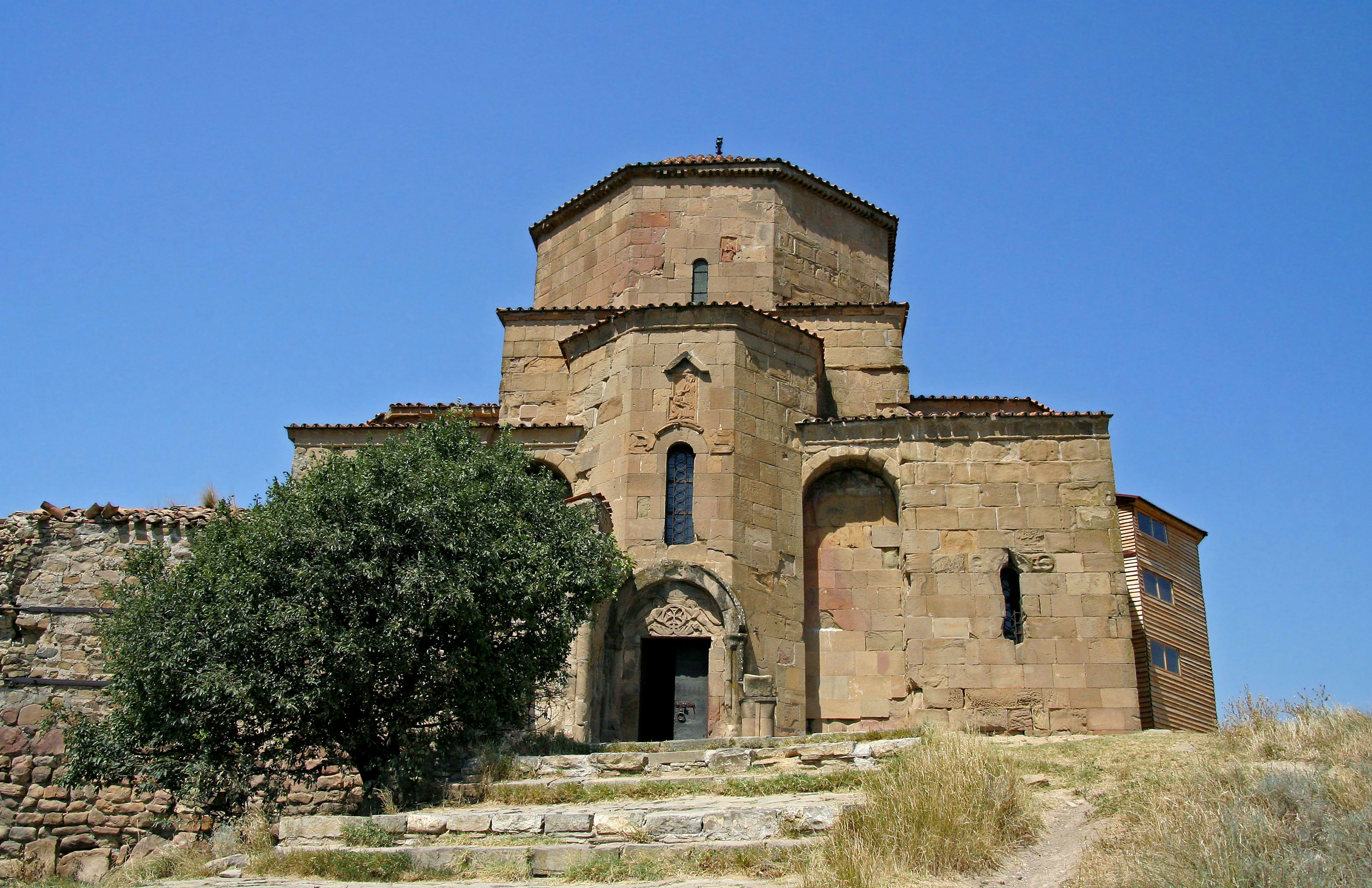 Une ancienne église en pierre se dresse sous un ciel bleu