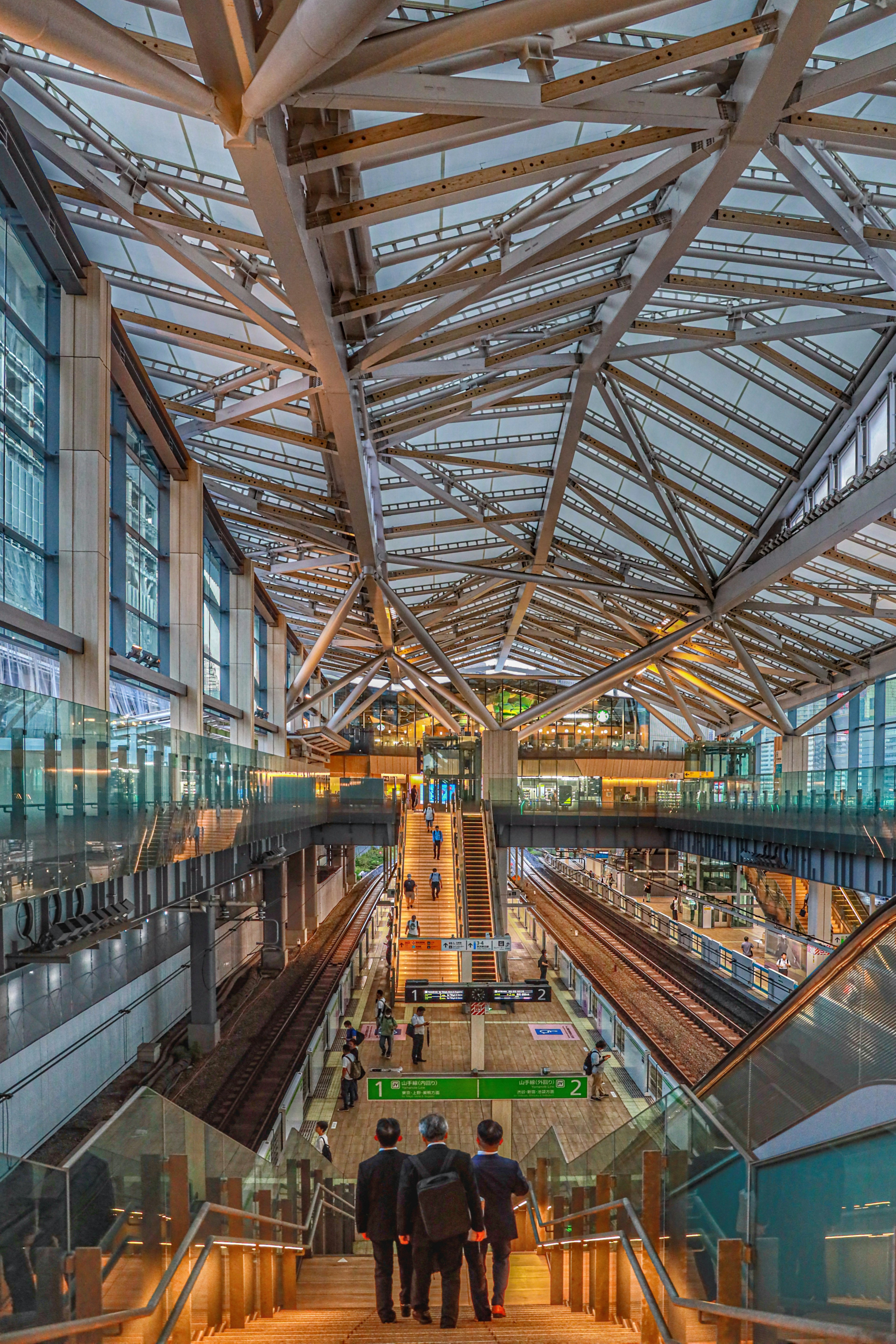 Vue intérieure d'une gare moderne mettant en valeur des treillis métalliques et des escalators