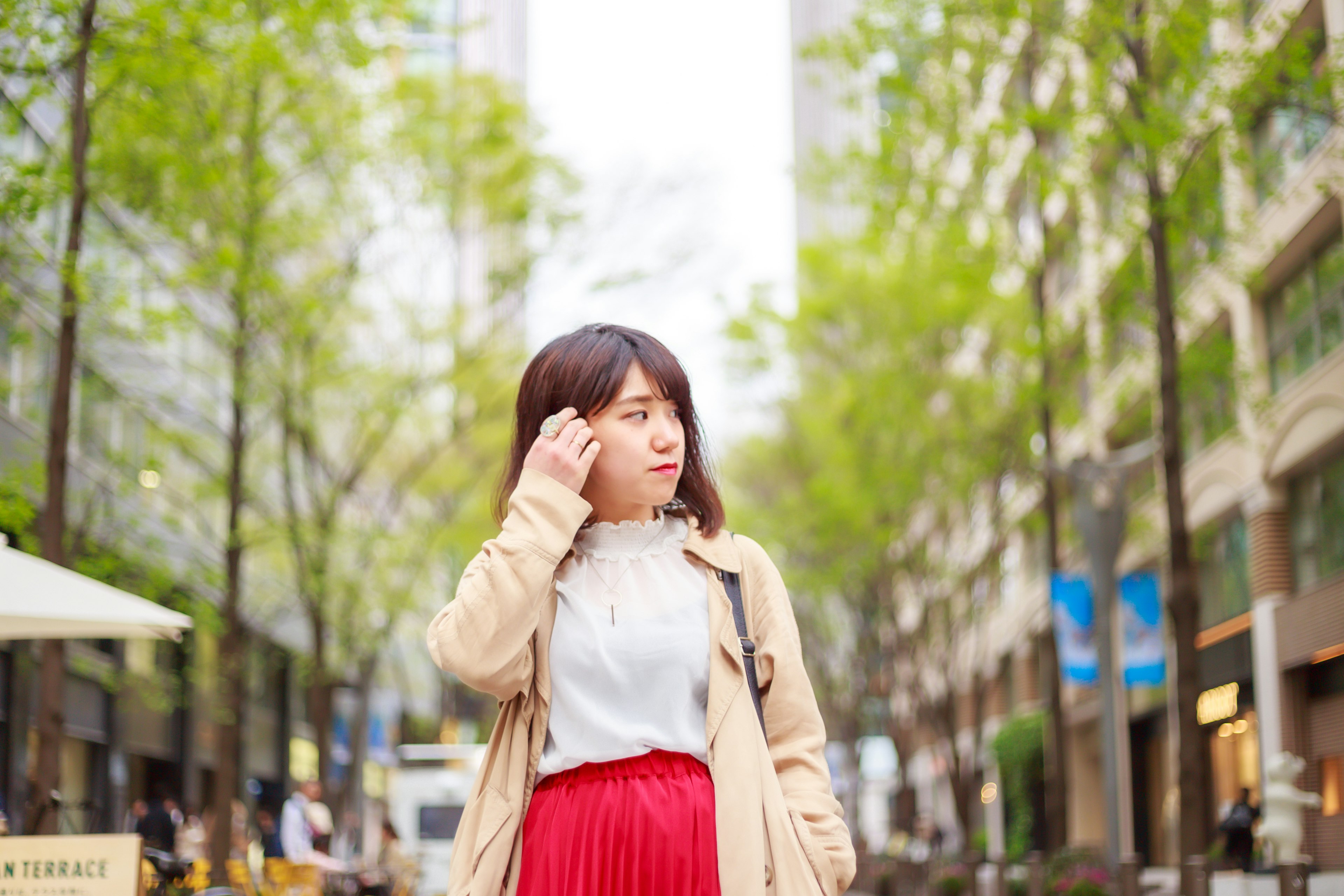 街路で赤いスカートを着た女性が立っている風景