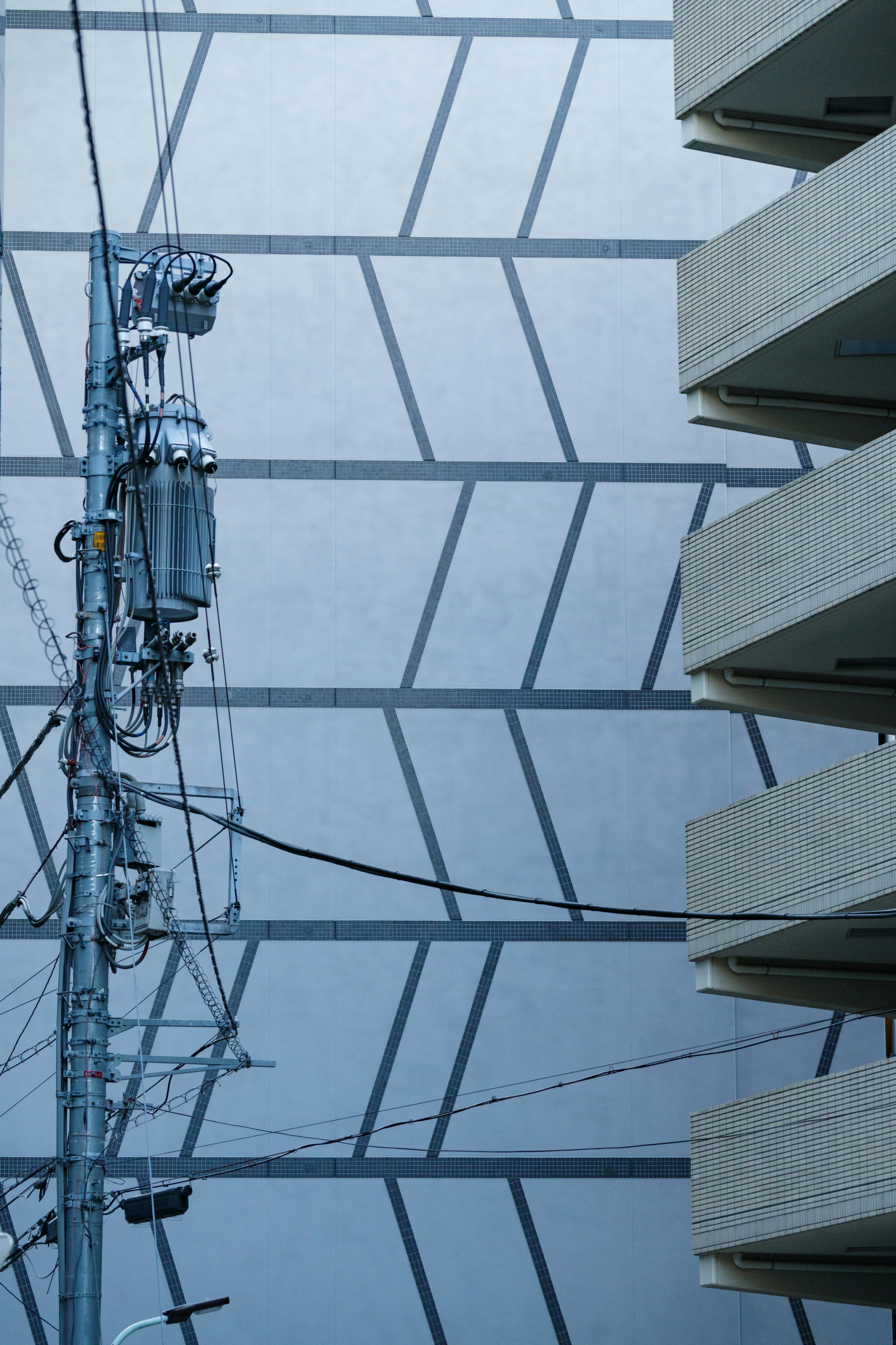 Urban scene featuring geometric patterns on a building and a power pole