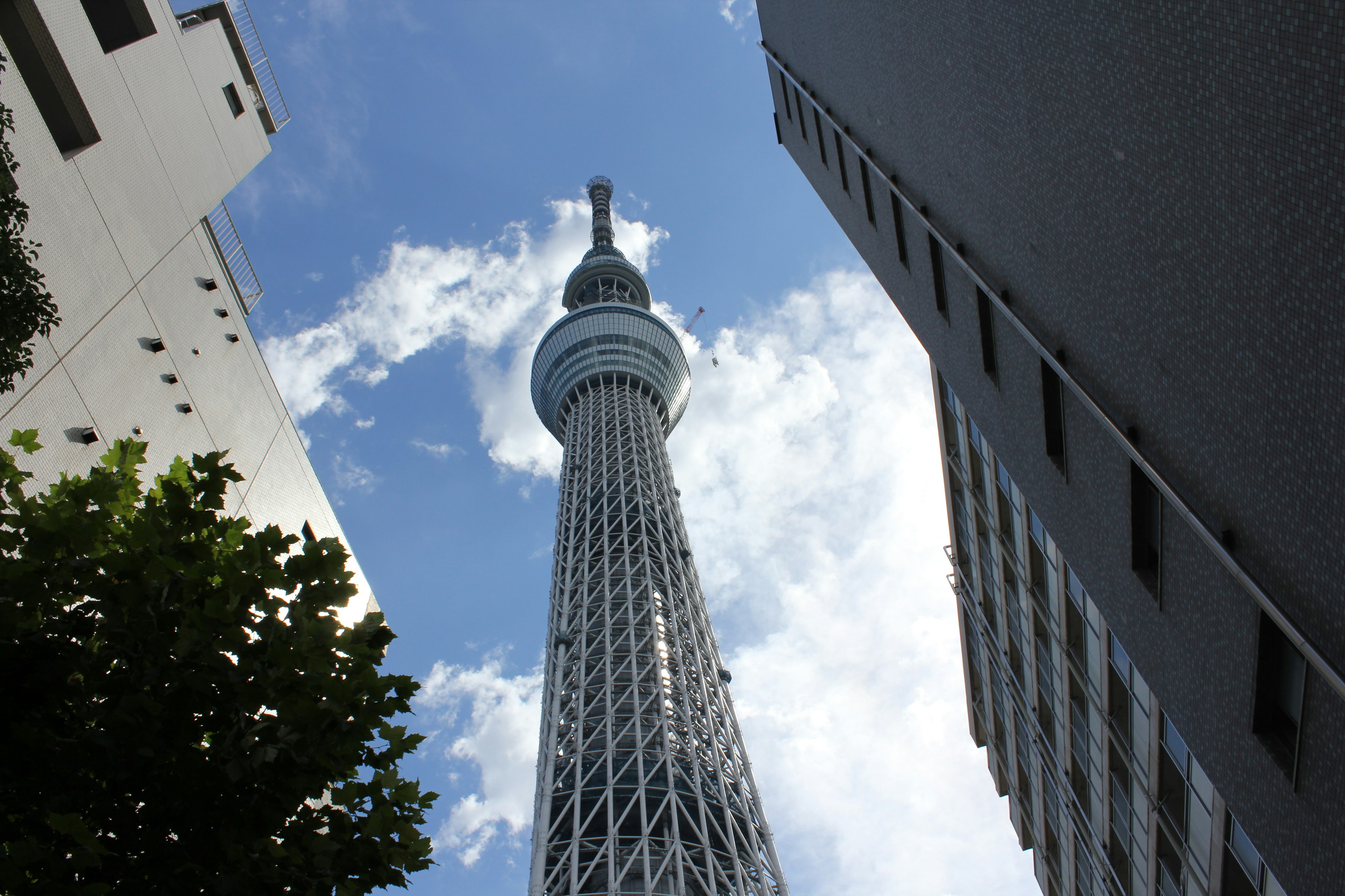 Blick auf den Tokyo Skytree von unten mit blauem Himmel und Wolken