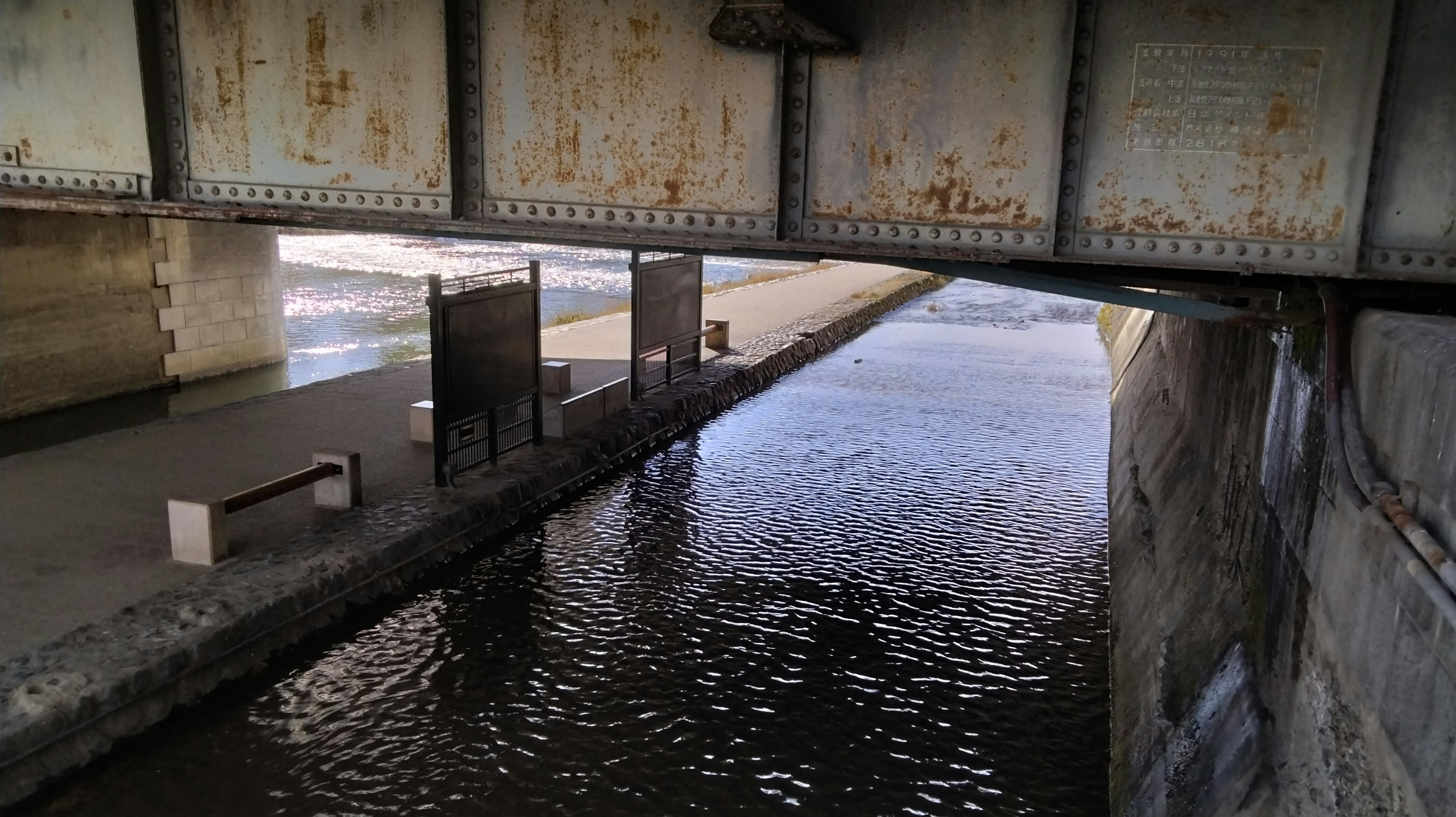 Sous un pont ferroviaire montrant la surface de l'eau et des détails structurels