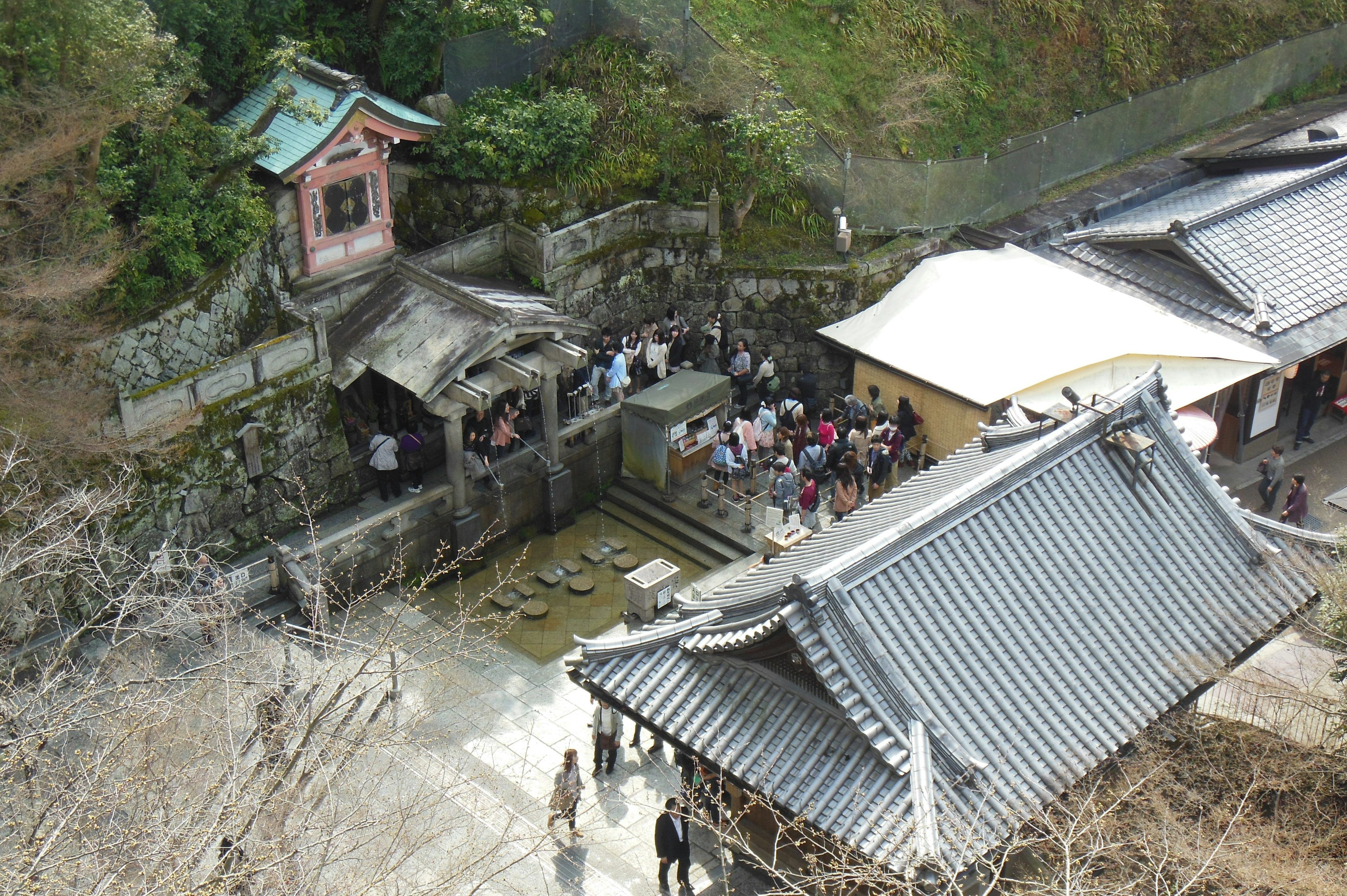 Vista aérea de un templo histórico en las montañas con personas reunidas