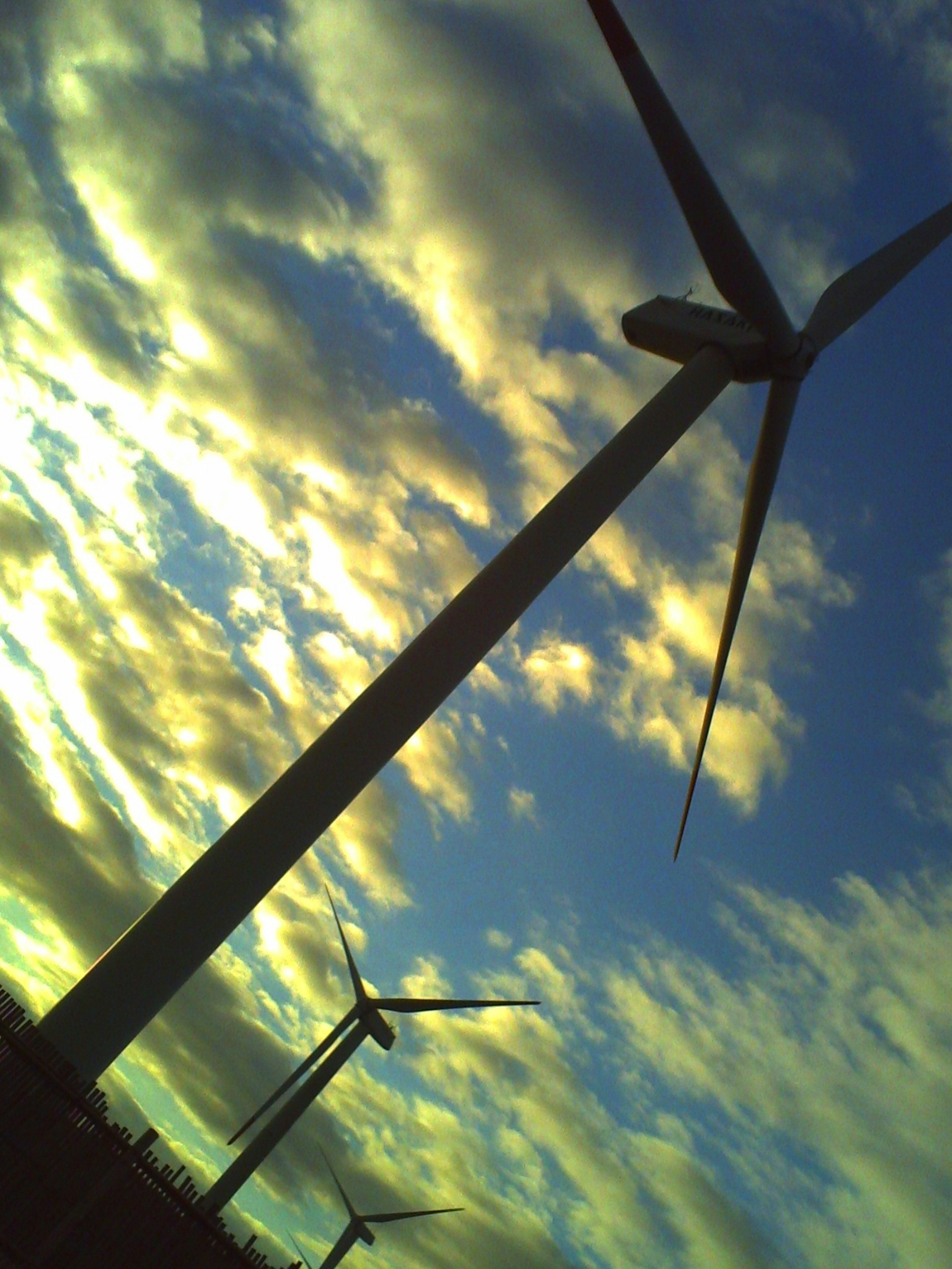 Silhouette of wind turbines against a cloudy sky