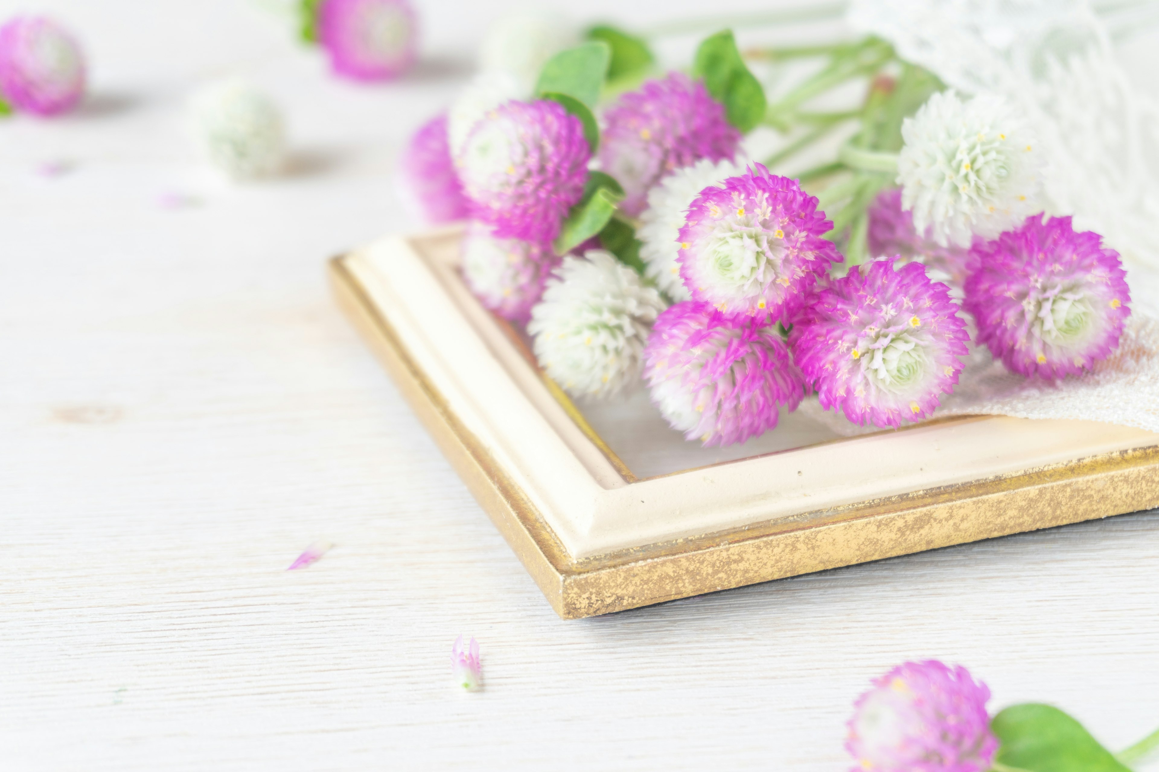 Arrangement de fleurs roses et blanches près d'un cadre en bois