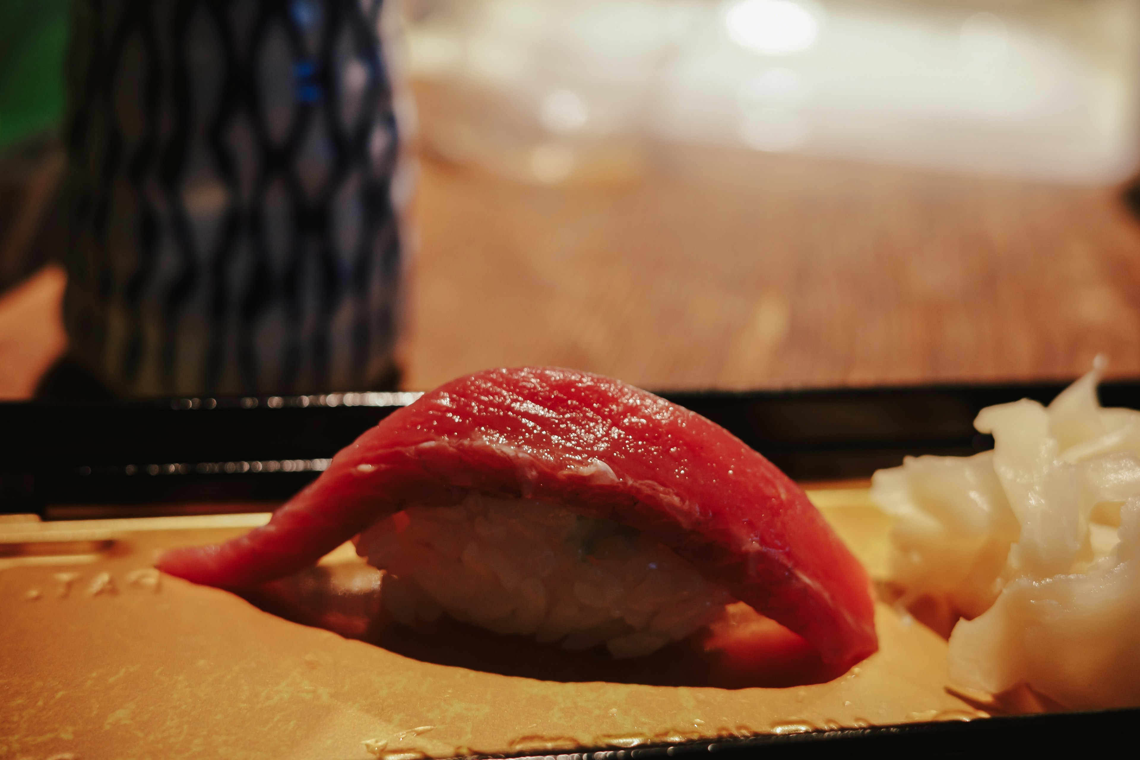 A beautifully plated sushi with fresh tuna sashimi on top