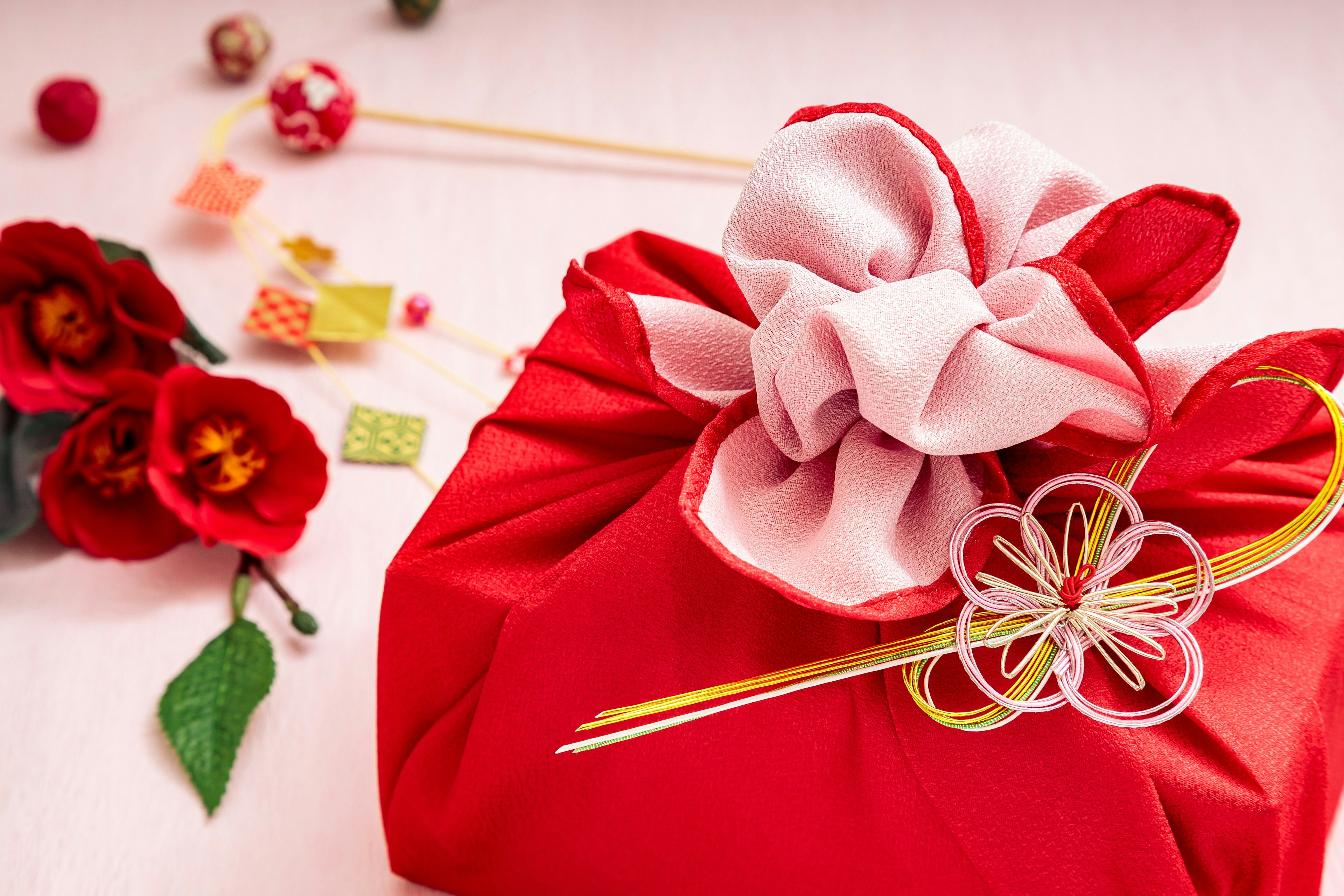 Cadeau enveloppé dans un furoshiki rouge avec décoration florale