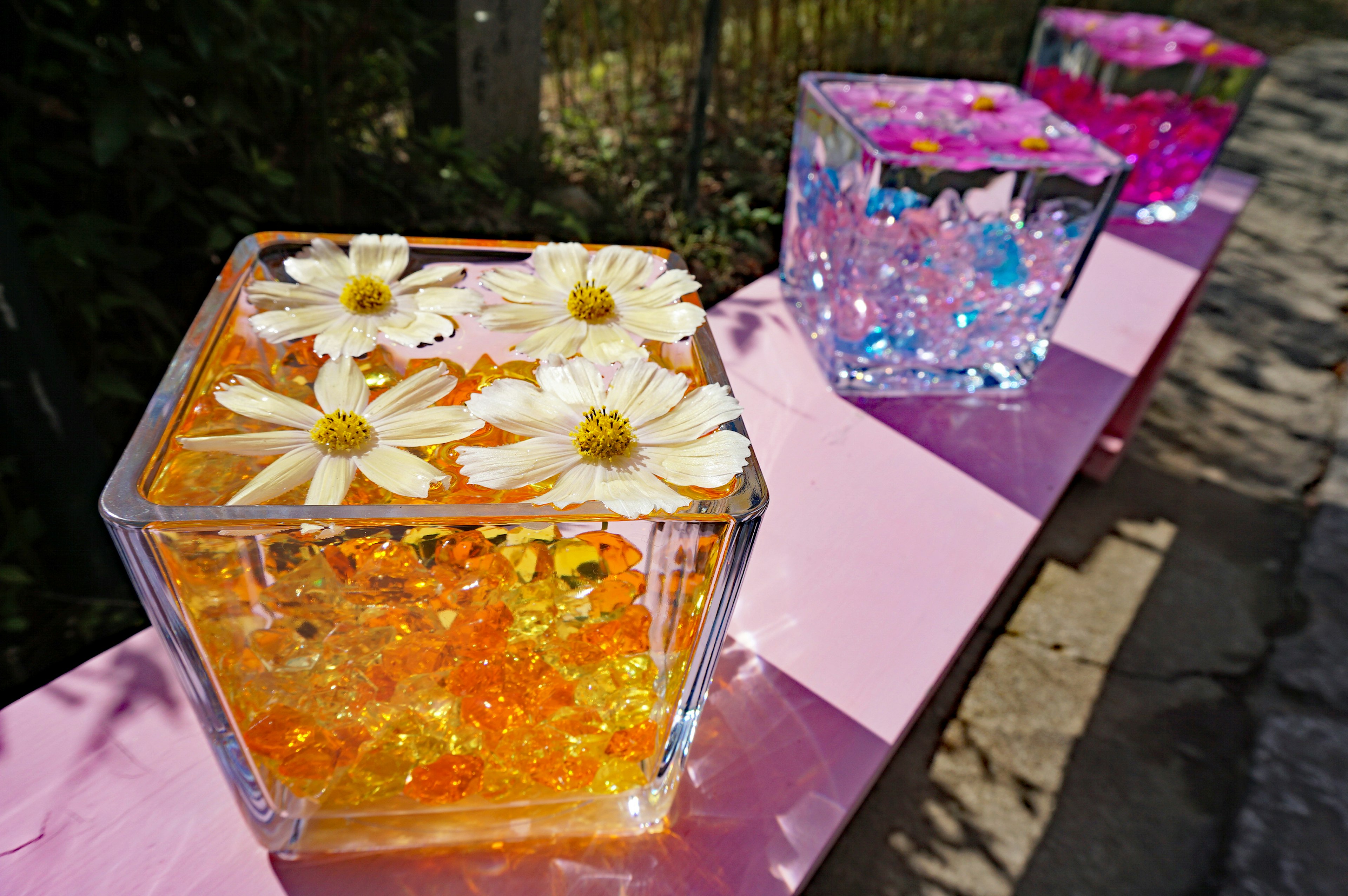 Colorful art pieces with flowers and beads in transparent containers