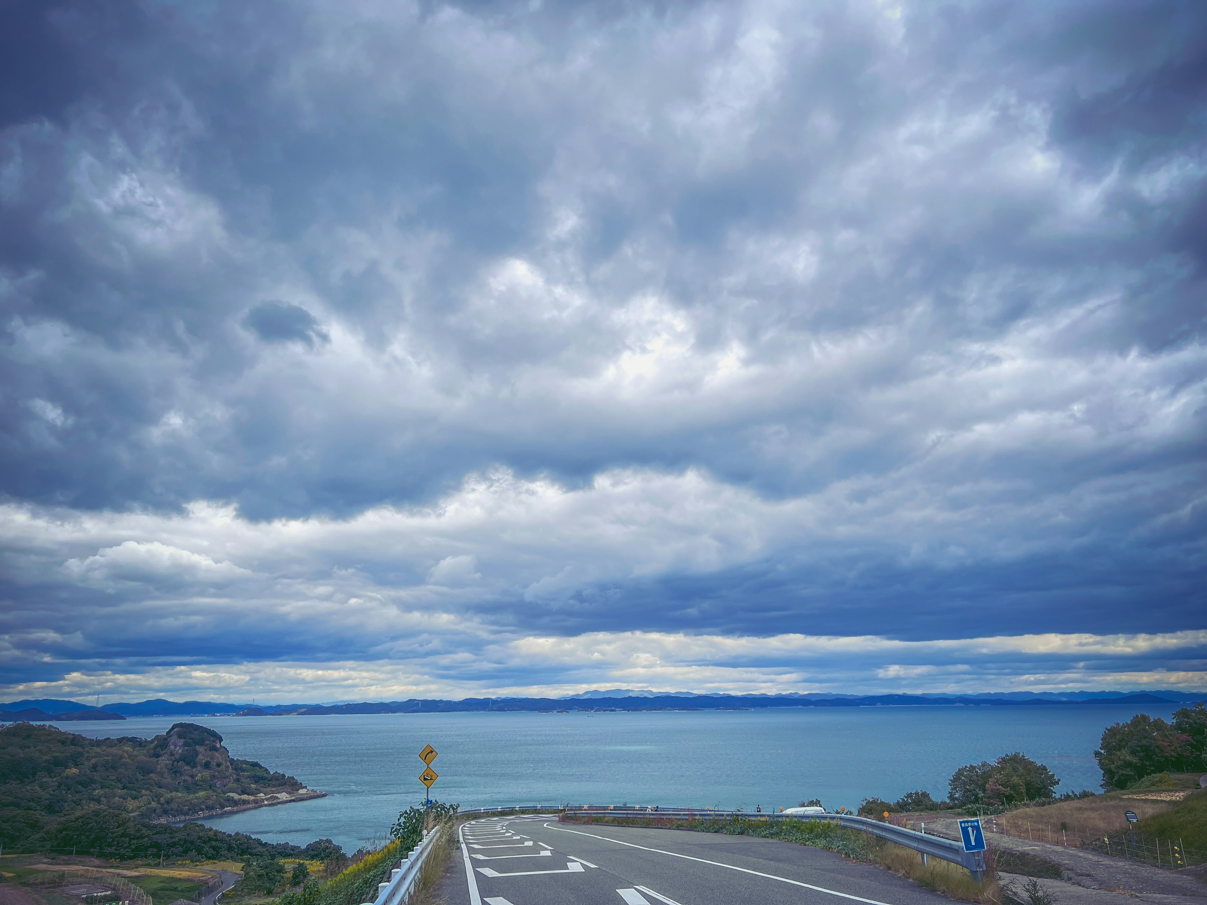 海と空の美しい風景 雲が広がる青い空 道路の先に見える海