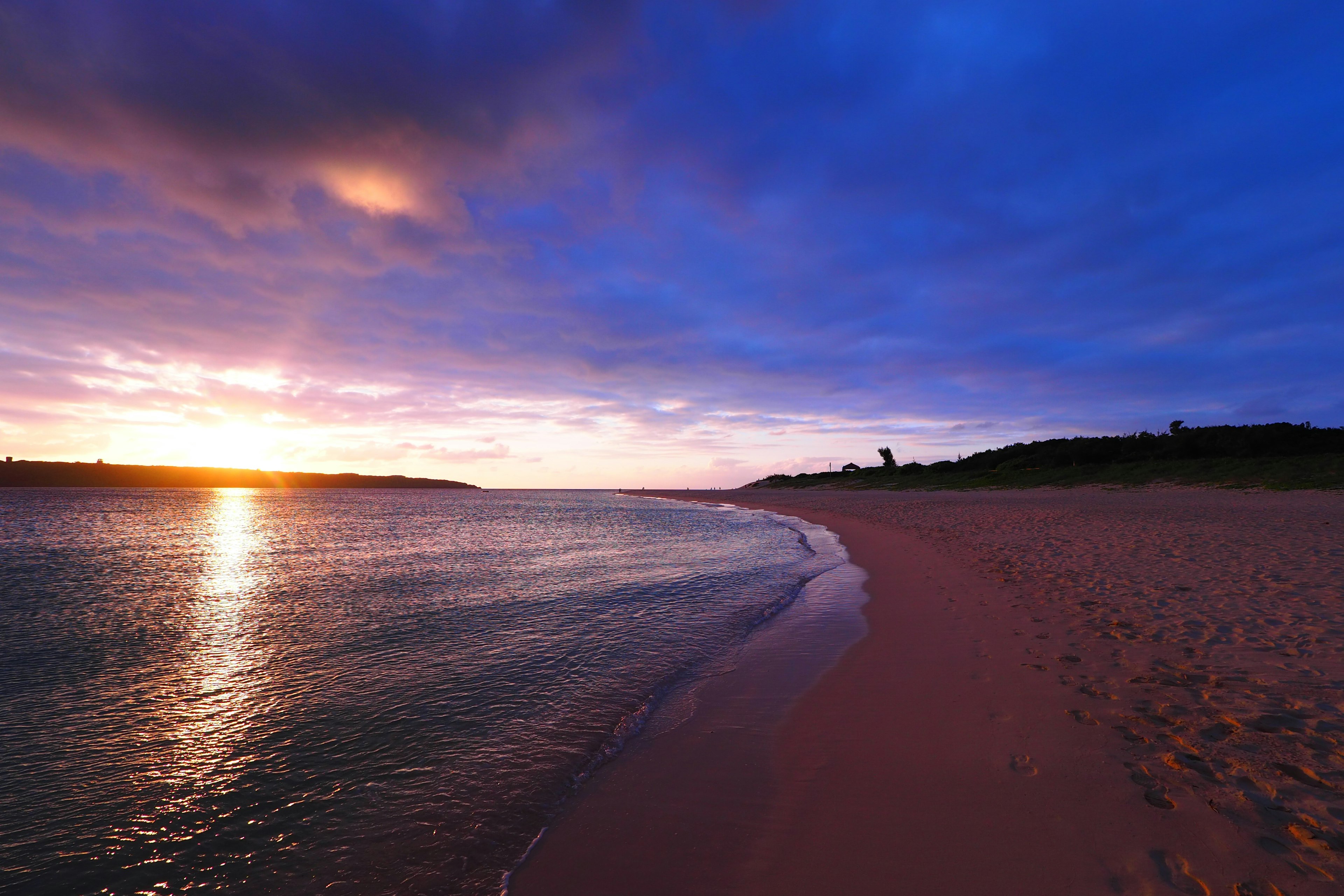 Schöner Sonnenuntergang über einem ruhigen Strand mit sanften Wellen