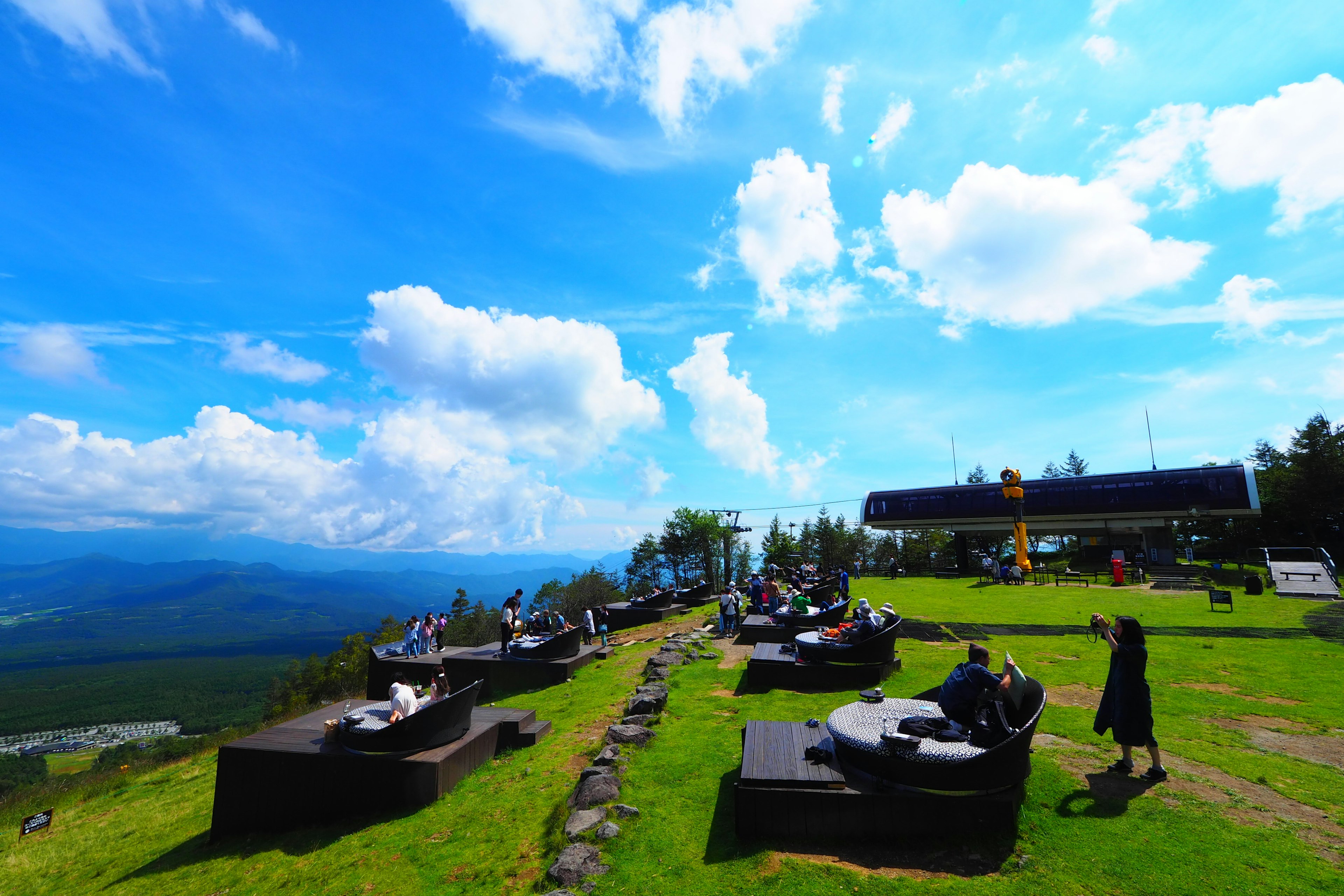 Mountain view with people sitting under a blue sky