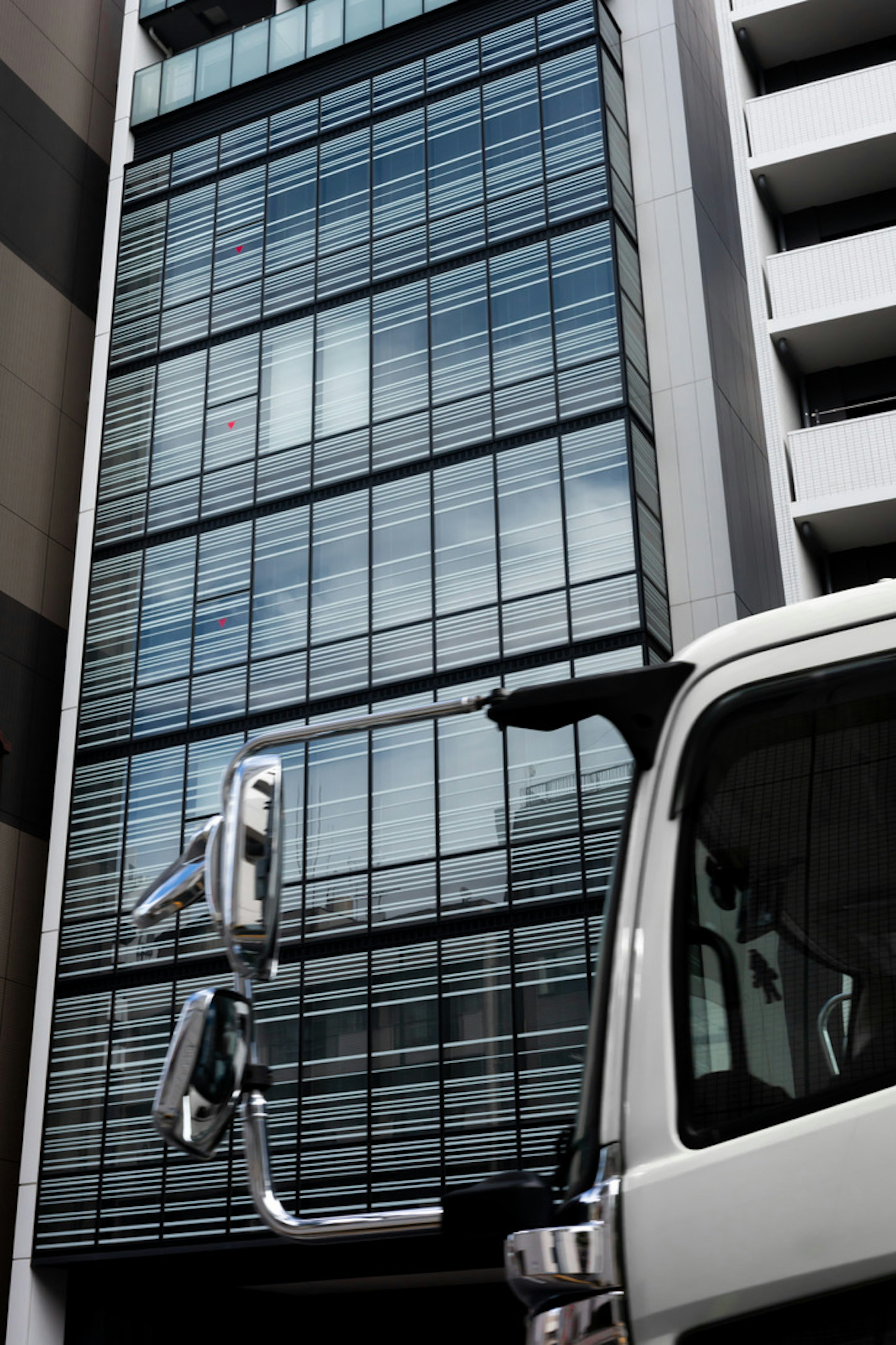 Scène urbaine avec un bâtiment en verre et une partie d'un camion