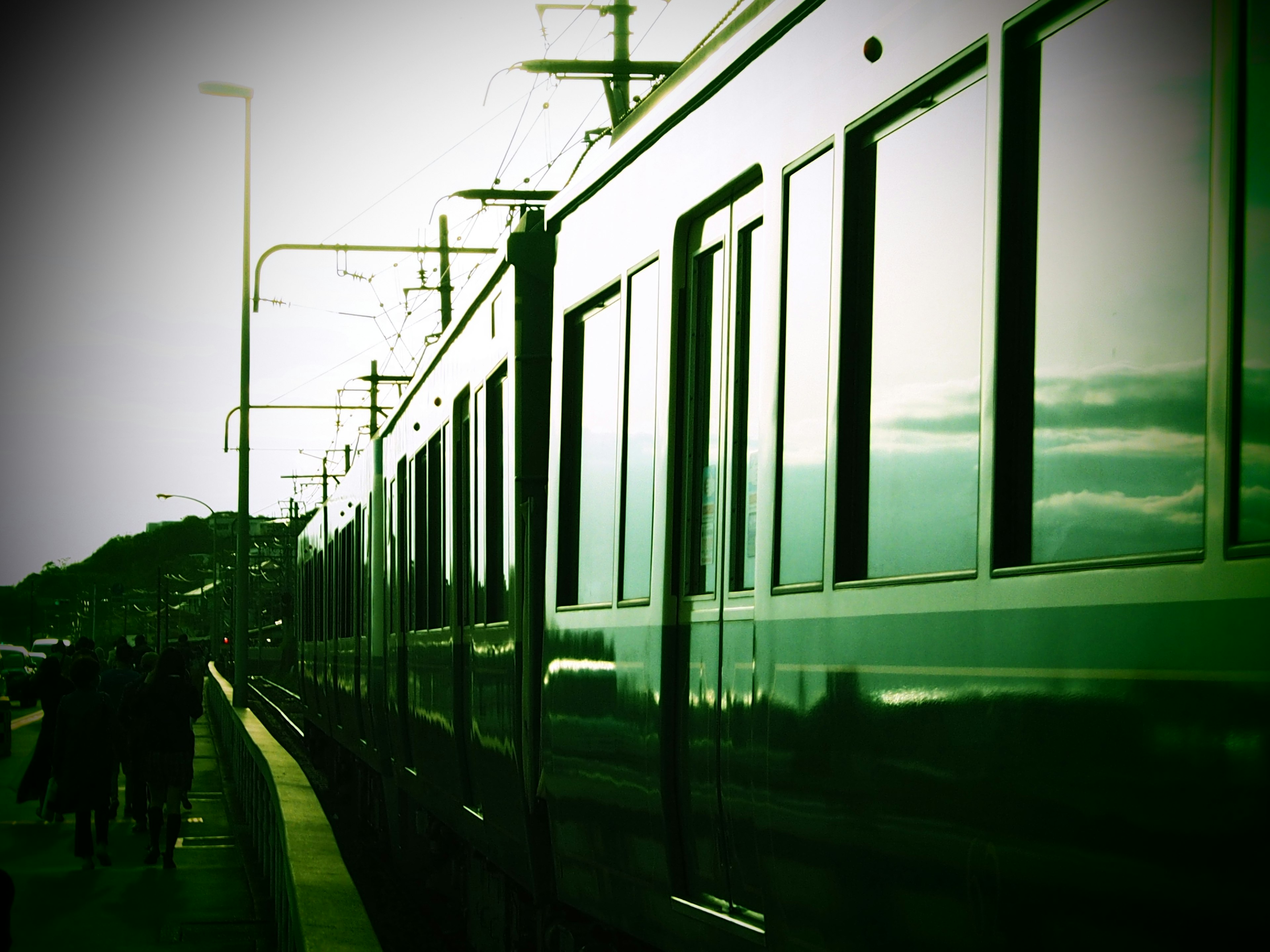 緑の電車が駅に停車している風景