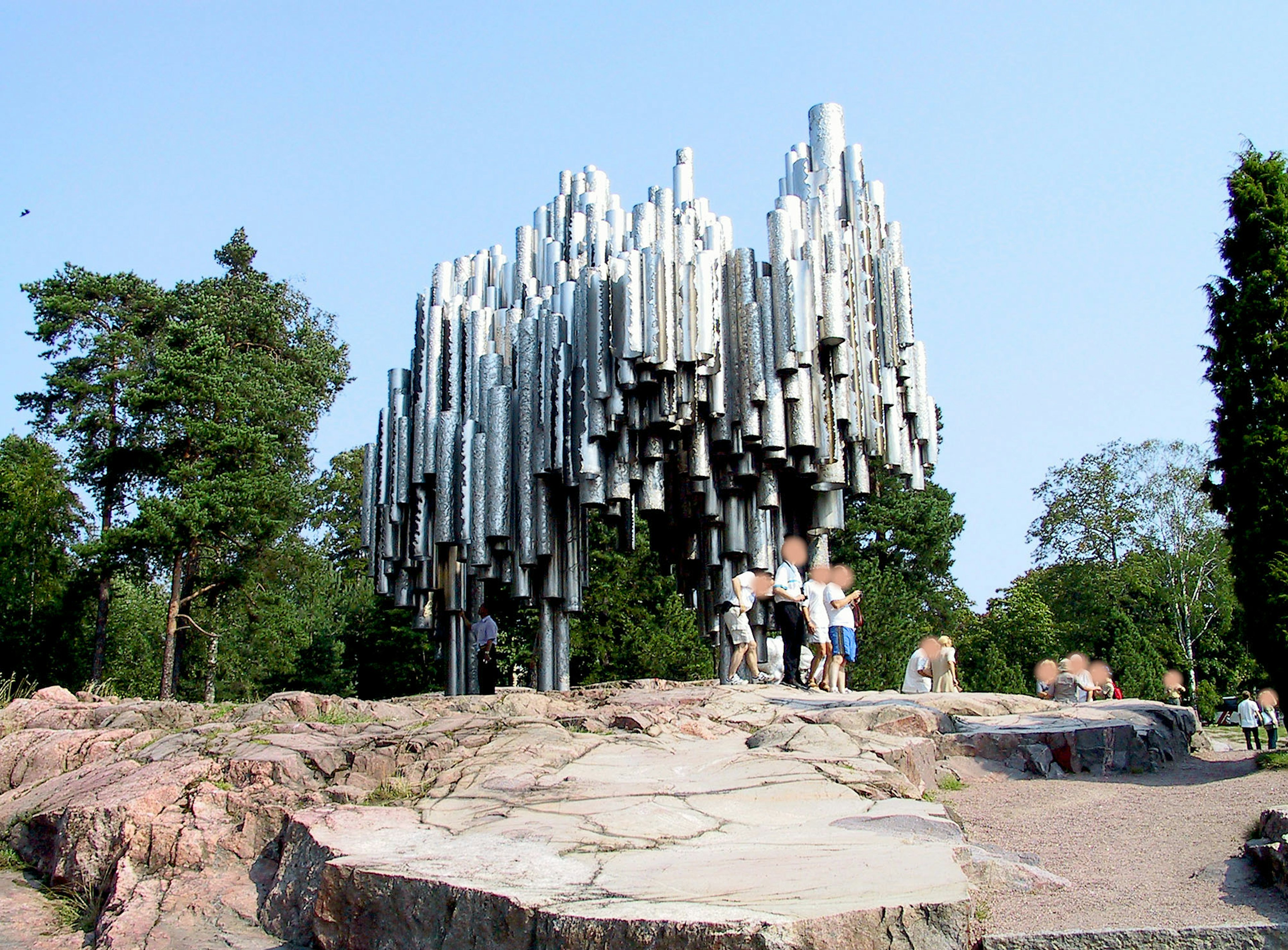 People gathering in front of the Sibelius Monument in a park